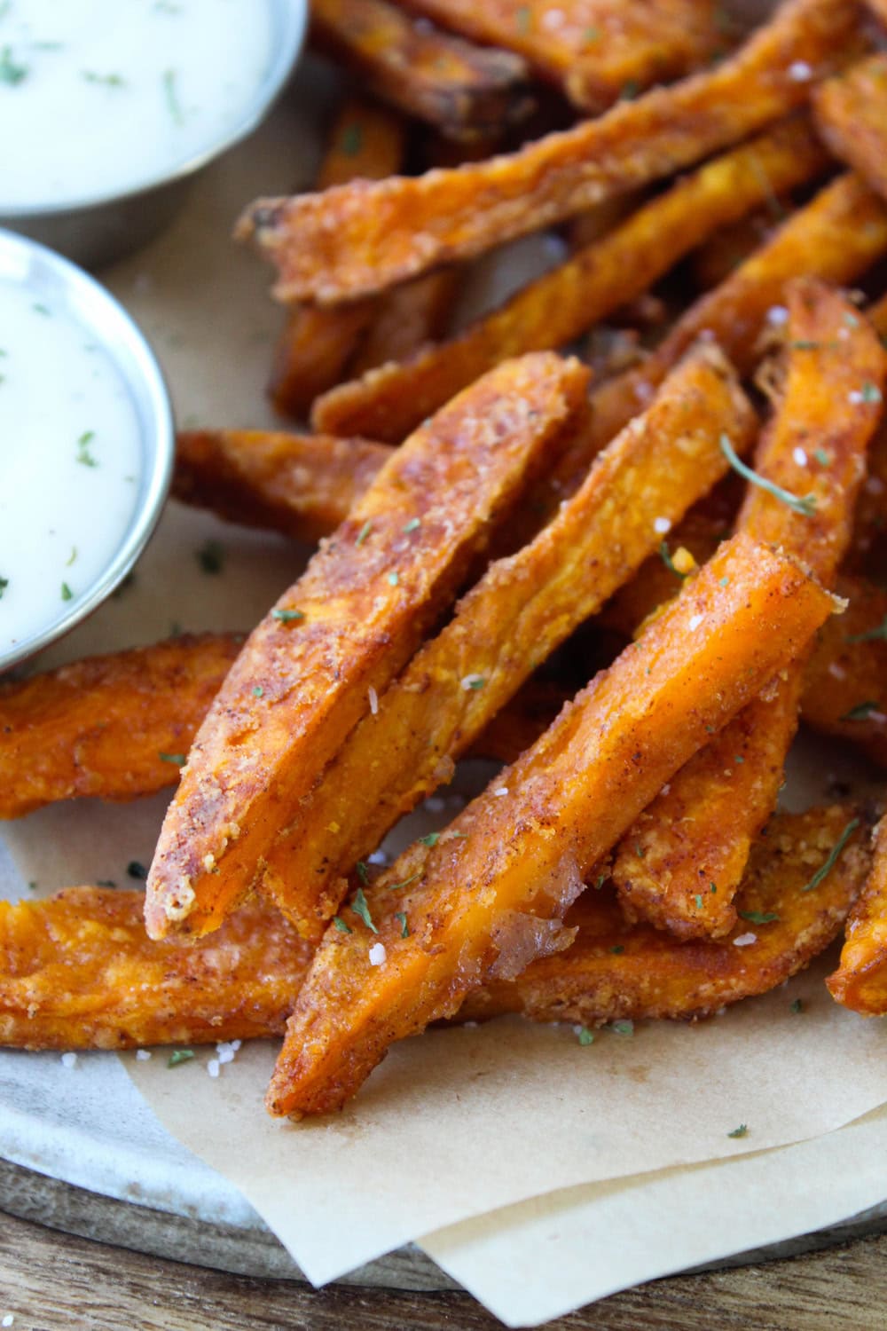 Seasoned oven baked sweet potato fries garnished with herbs and salt