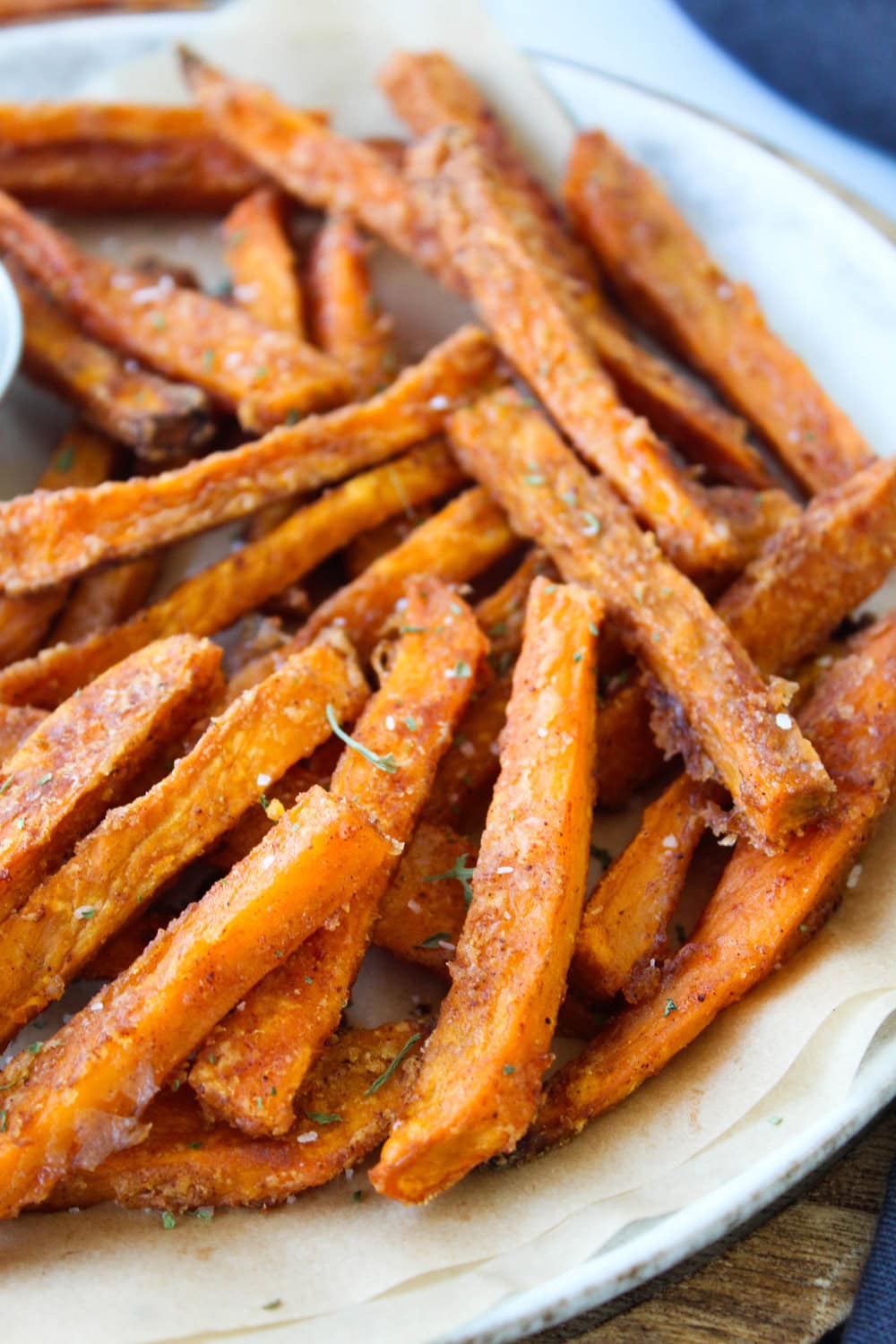 Crispy oven baked sweet potato fries in a bowl lined with parchment paper.