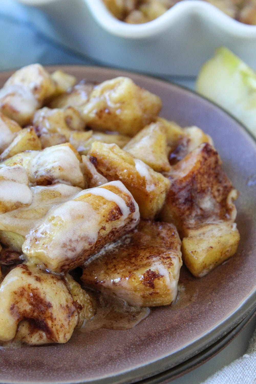 Warm apple fritter cinnamon roll casserole with glaze