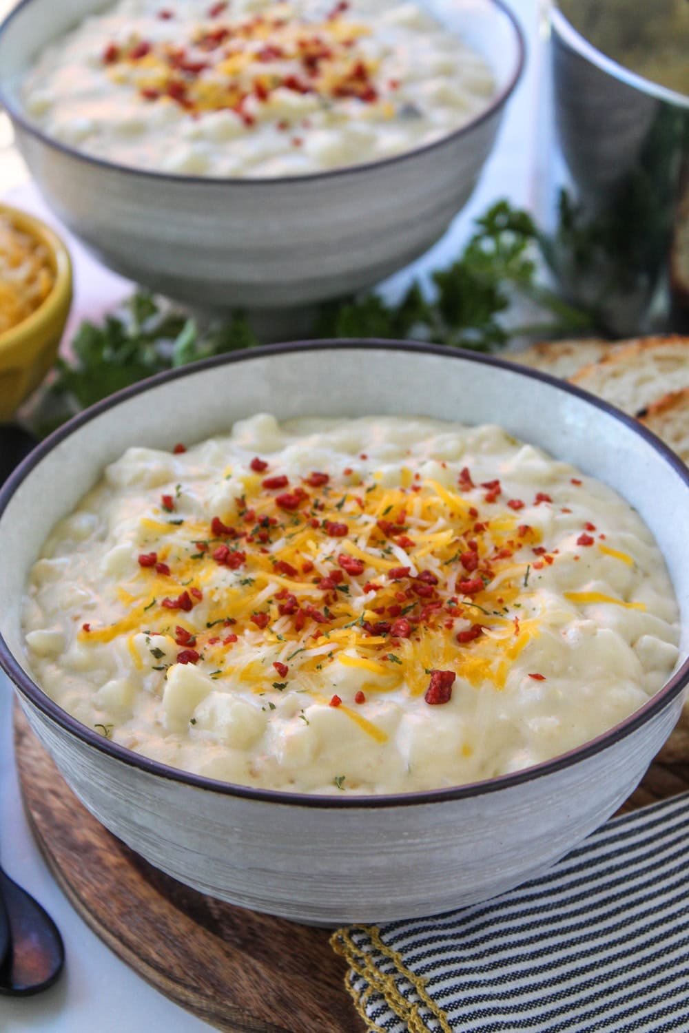 Bowl of easy cheesy potato soup topped with shredded cheddar