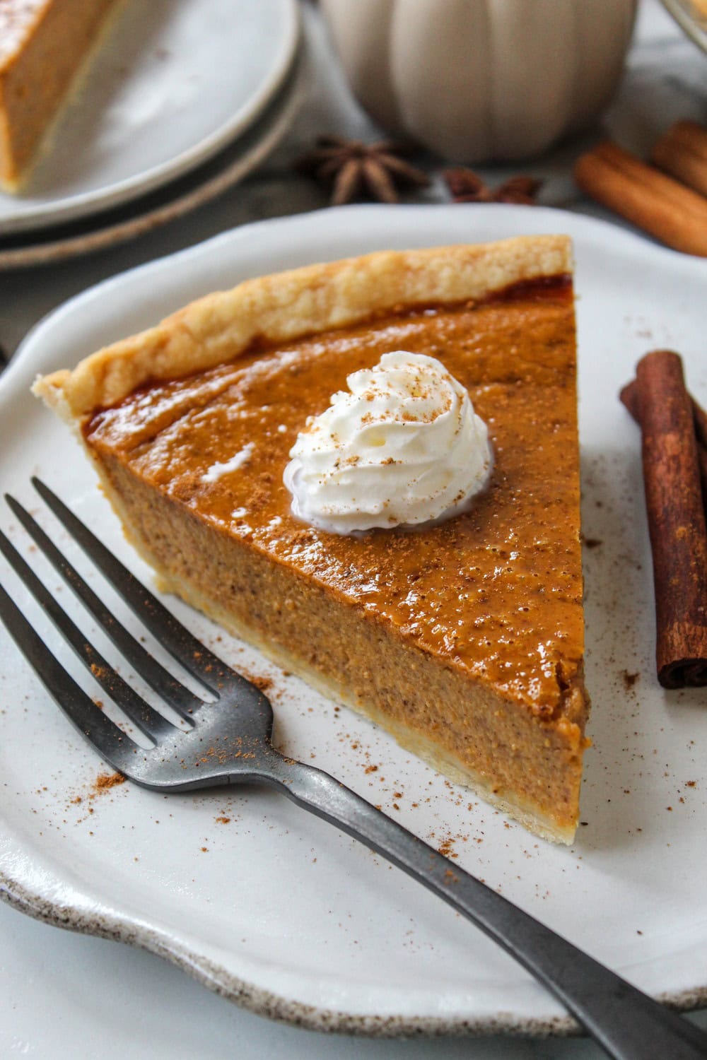 Easy pumpkin pie topped with whipped cream and sprinkled with cinnamon