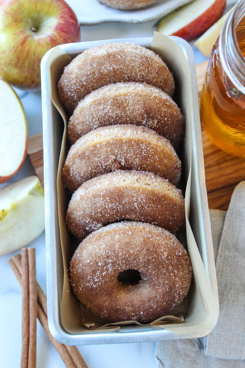 Golden baked apple cider donuts covered in cinnamon sugar, ready to serve with a warm fall-inspired flavor