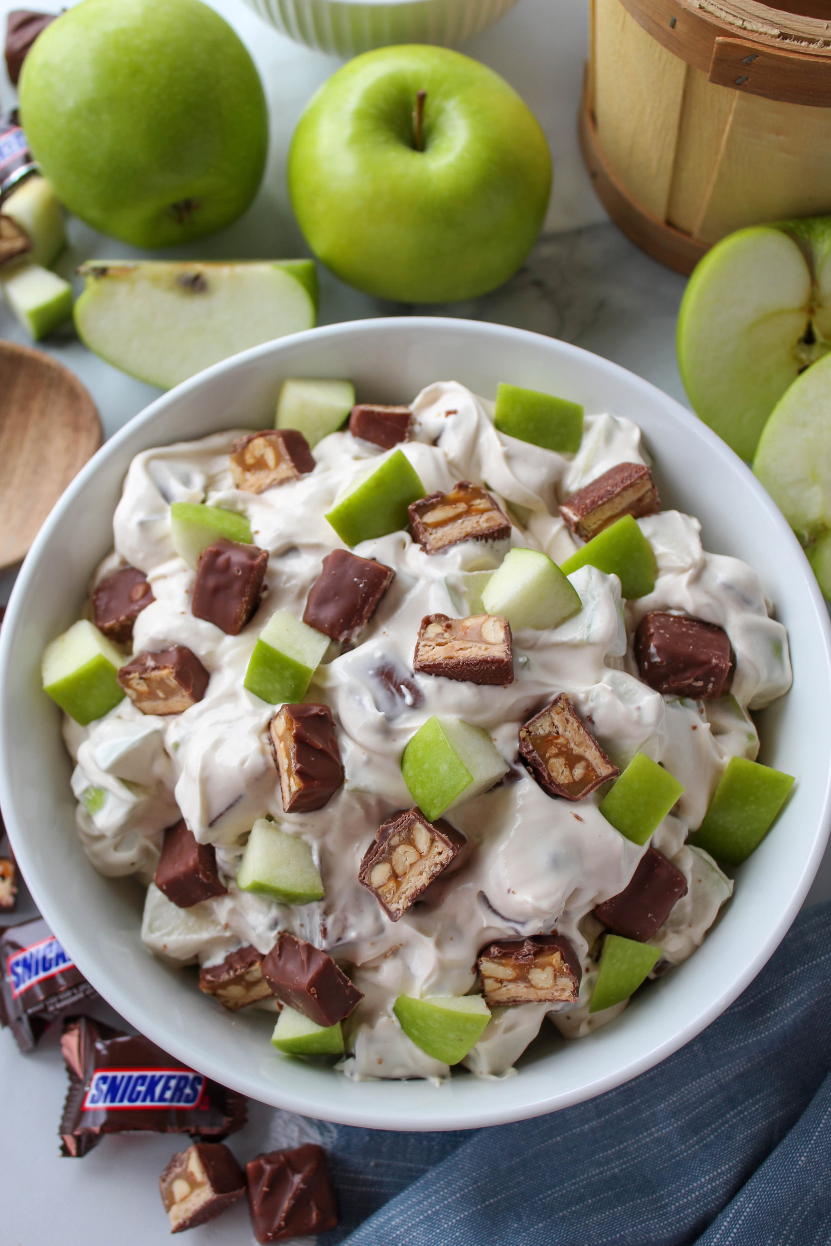 Snickers apple salad with chopped apples, candy bars, and creamy whipped topping