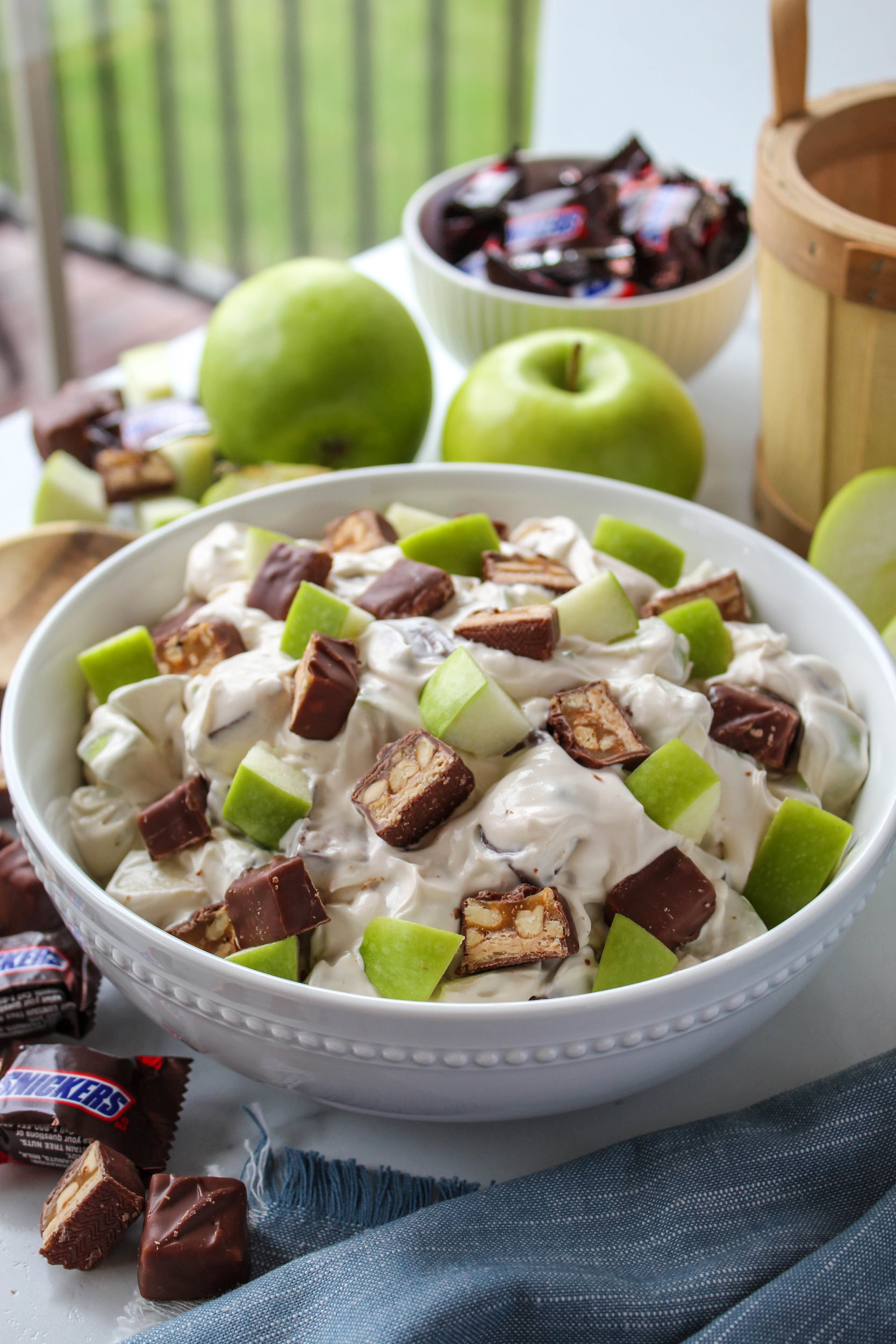 Creamy Snickers apple salad with caramel, apples, and chocolate pieces