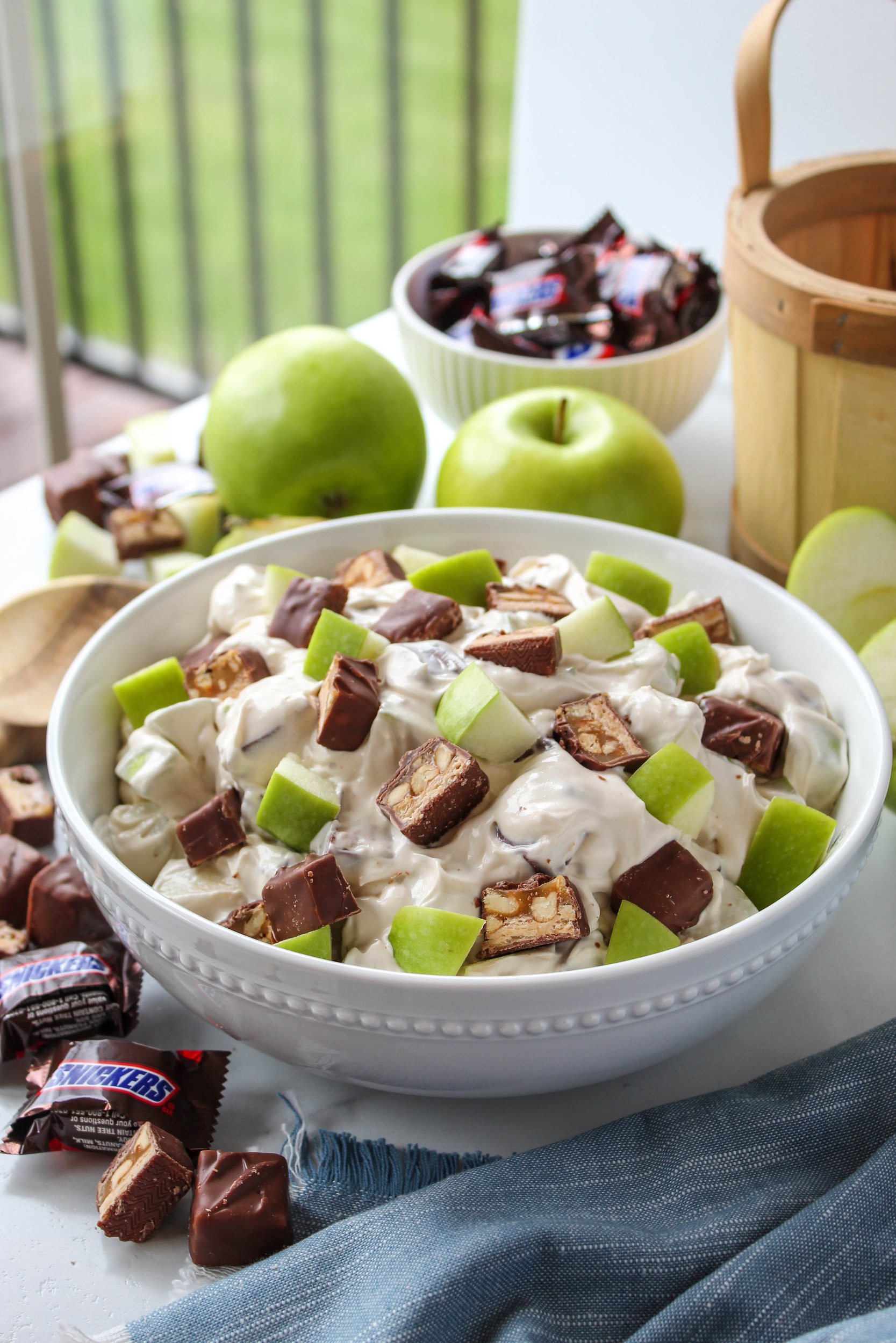 Easy Snickers apple salad recipe with apples, Cool Whip, and chopped Snickers bars