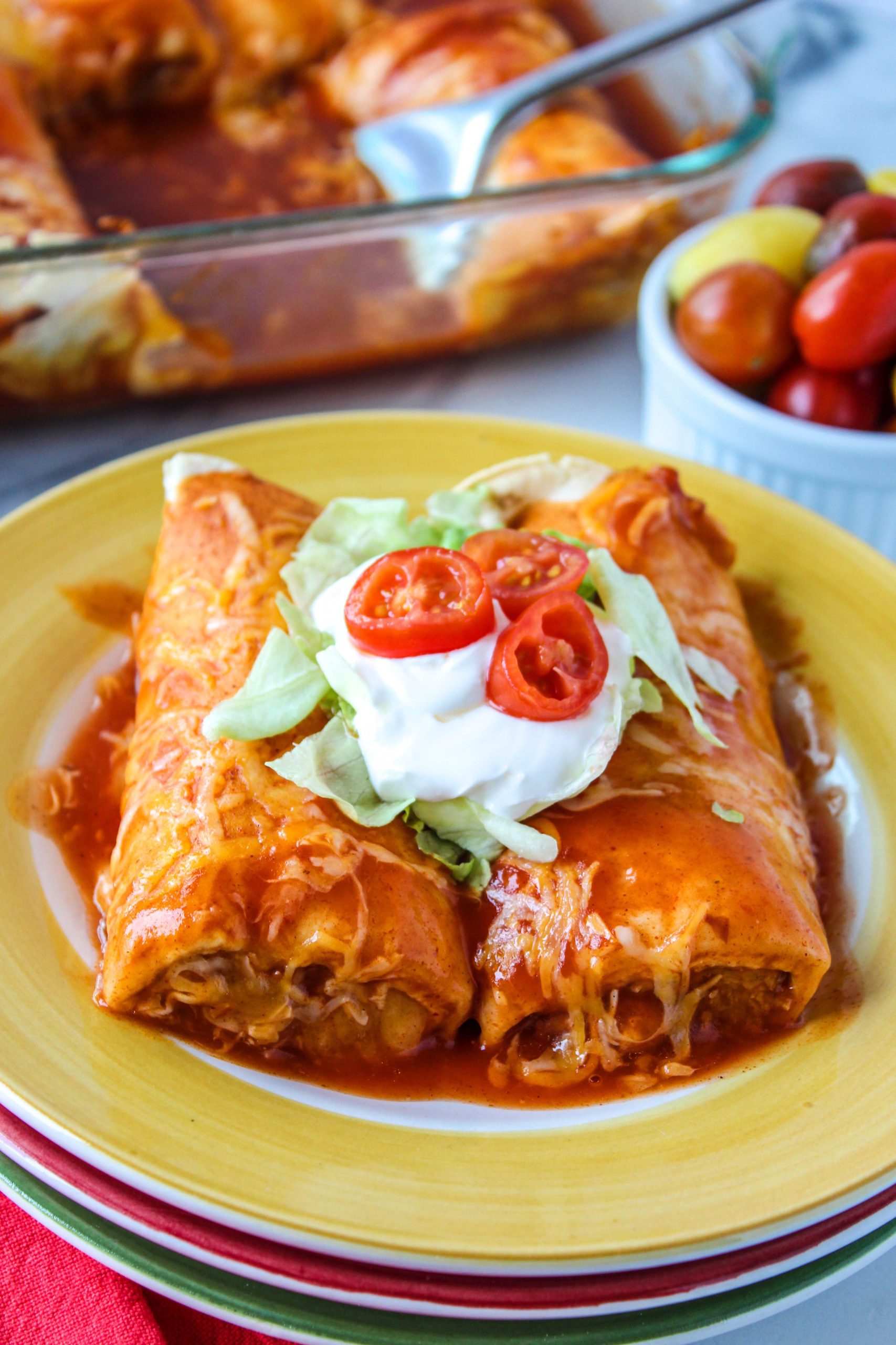 Vegetarian enchiladas topped with melted cheese and enchilada sauce