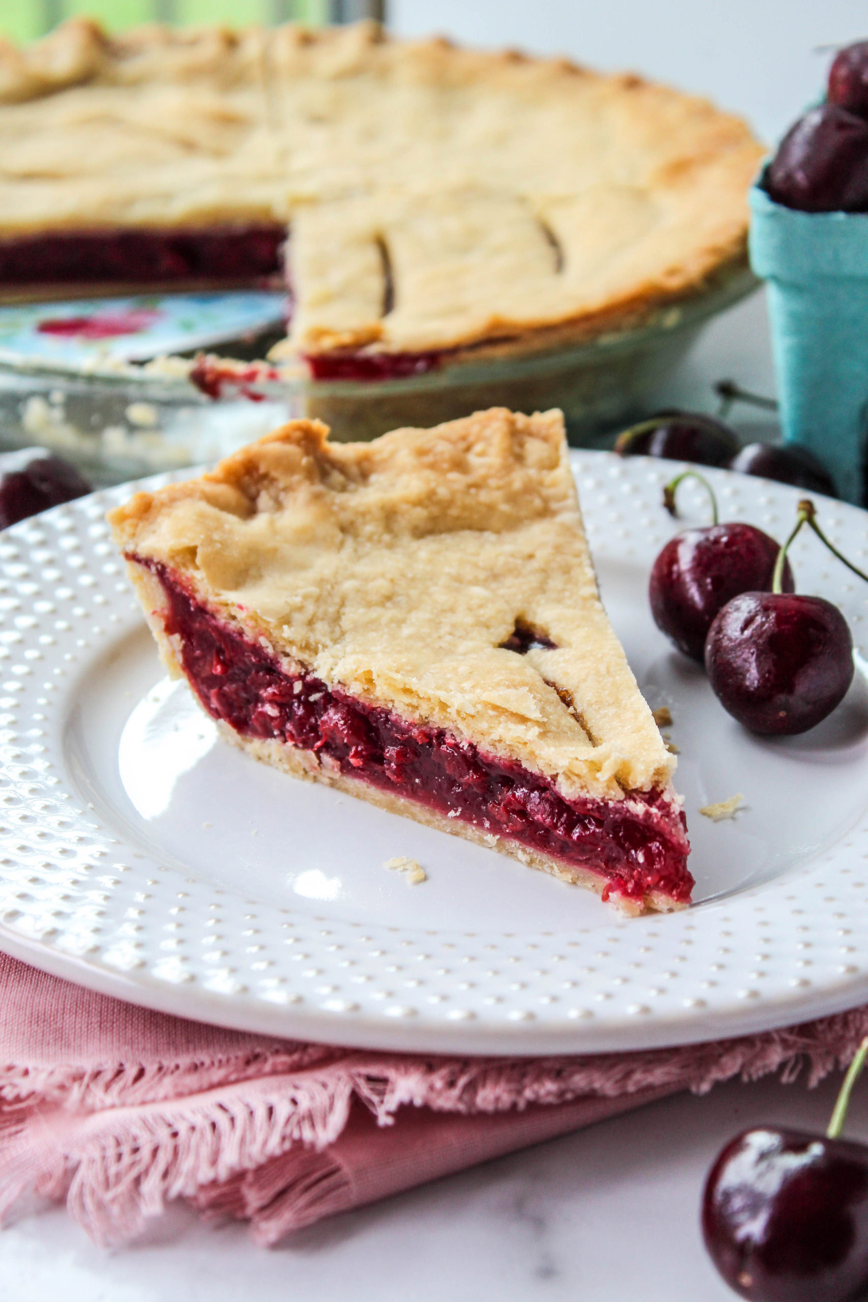 Homemade cherry pie with golden flaky crust on a plate