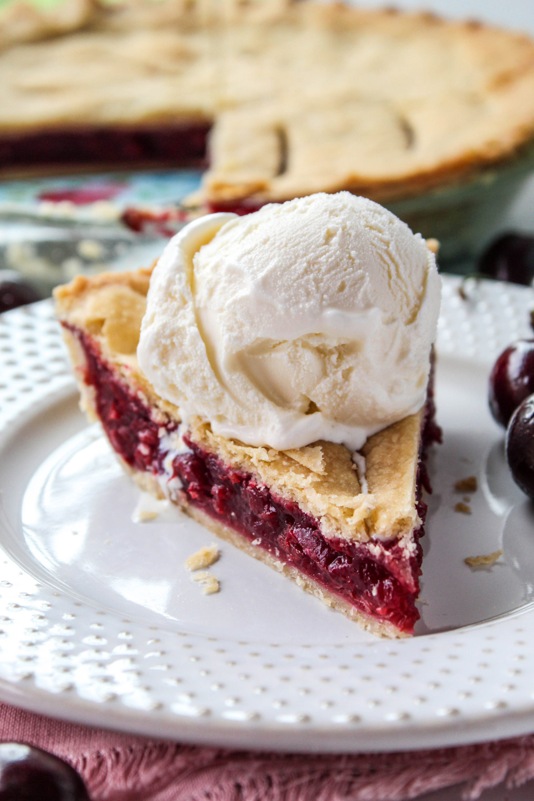 Slice of homemade cherry pie with bright red cherry filling