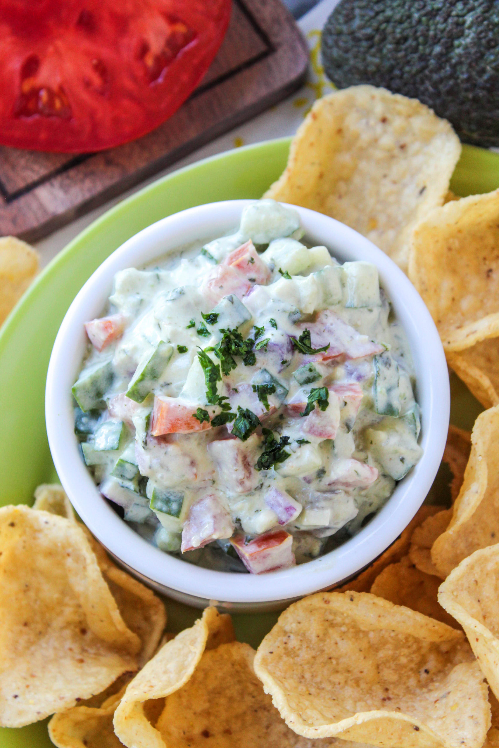 Creamy cucumber avocado salsa topped with cilantro in a white serving bowl