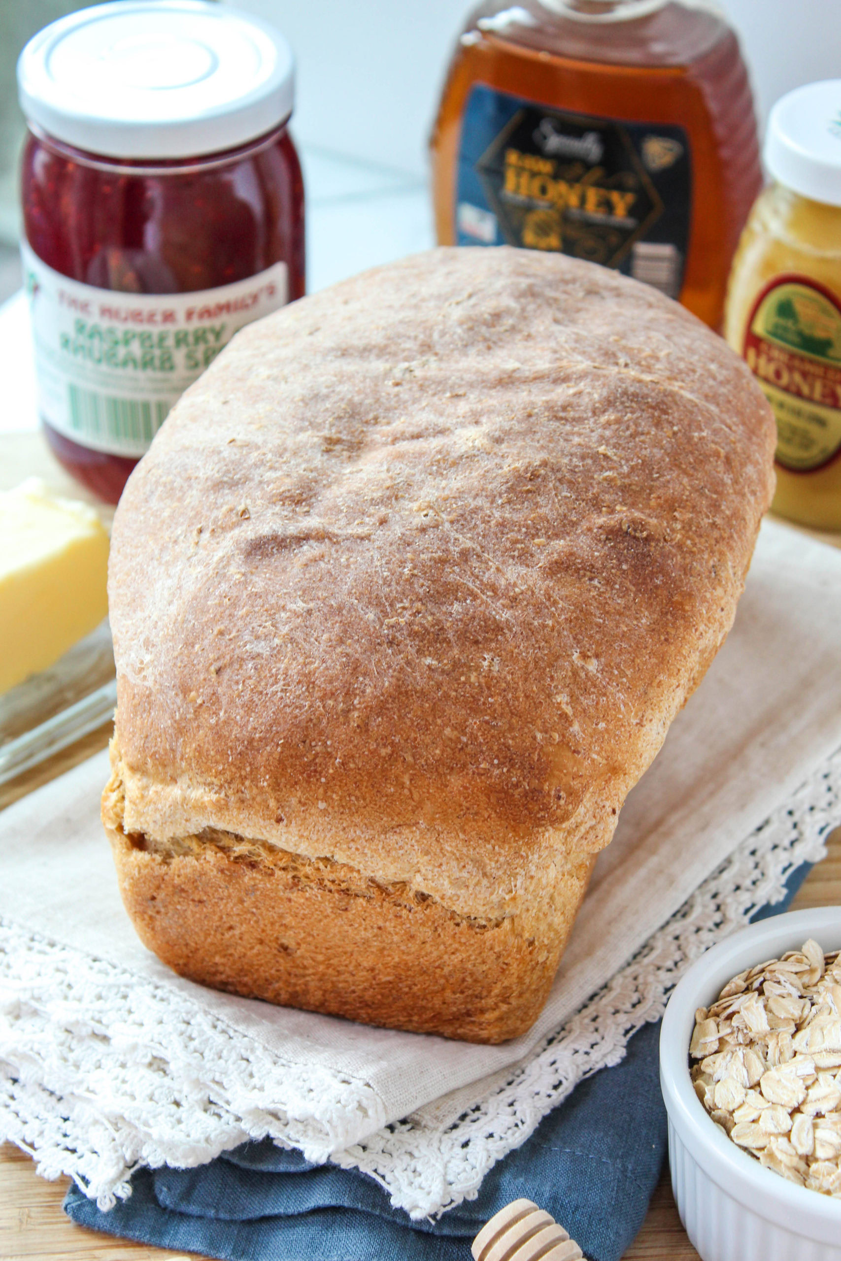 Freshly baked homemade oatmeal bread loaf with a golden crust on a wooden board