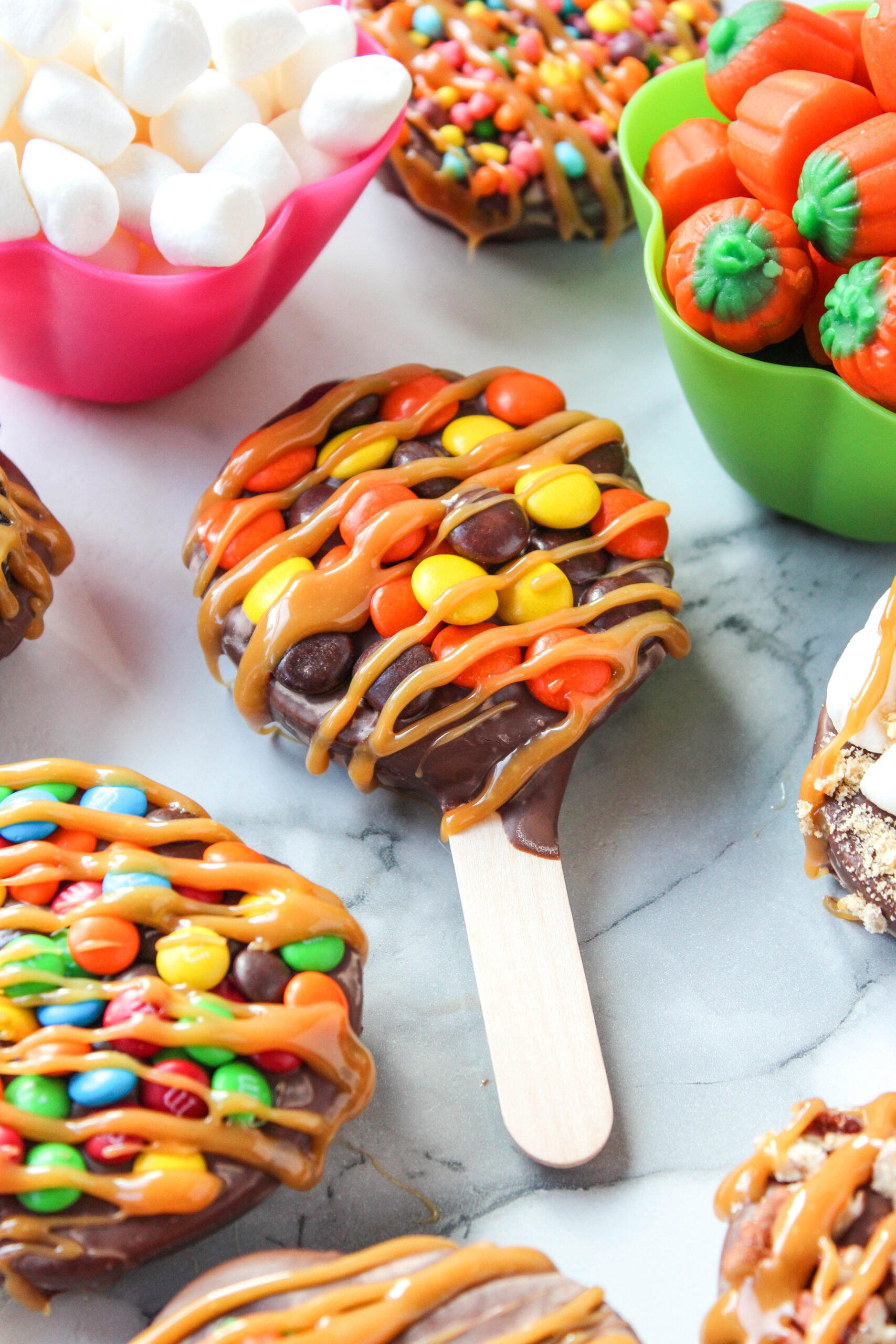 Fall-themed chocolate caramel candied apple pops with festive toppings
