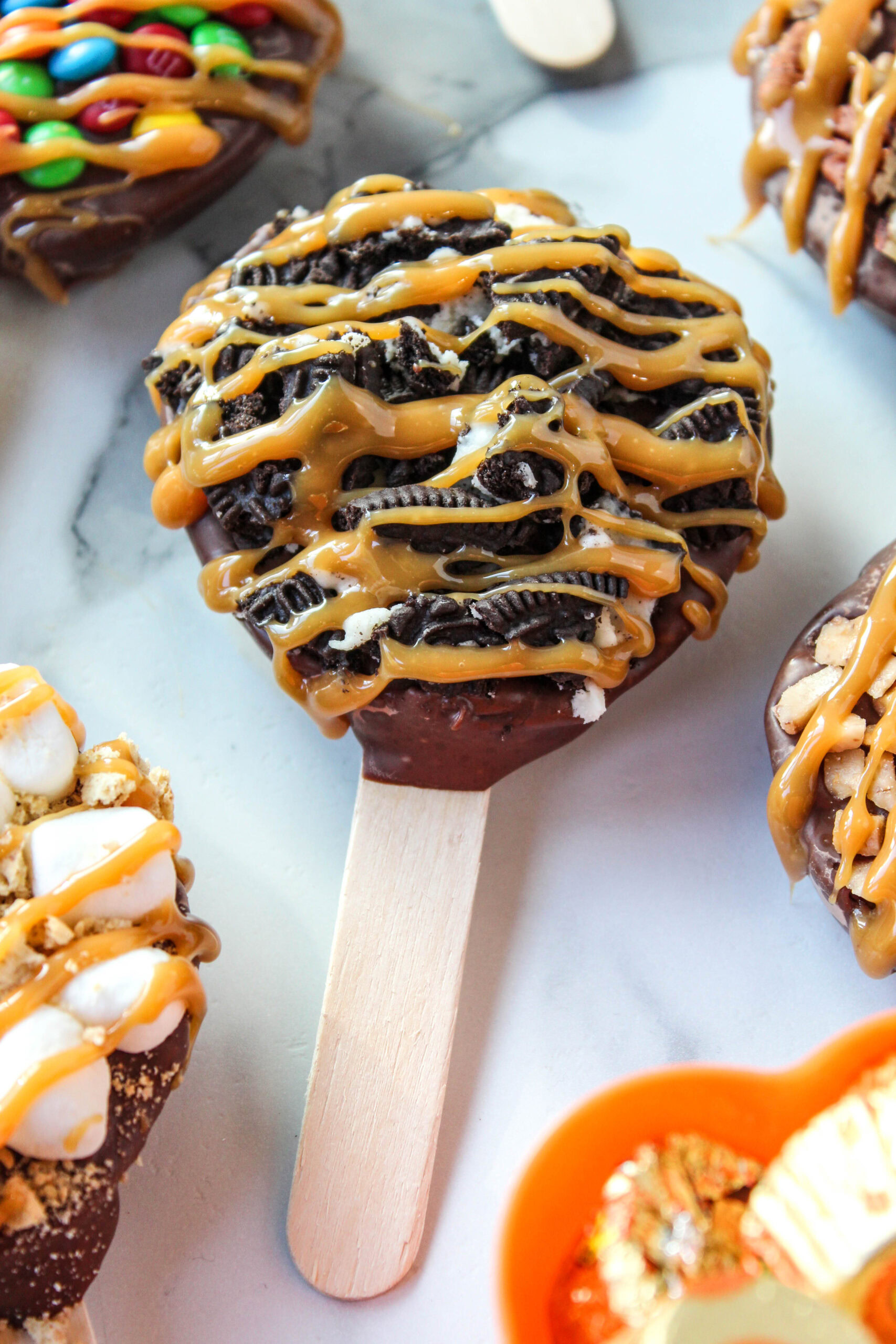 Gourmet chocolate caramel candied apple pops on wooden sticks