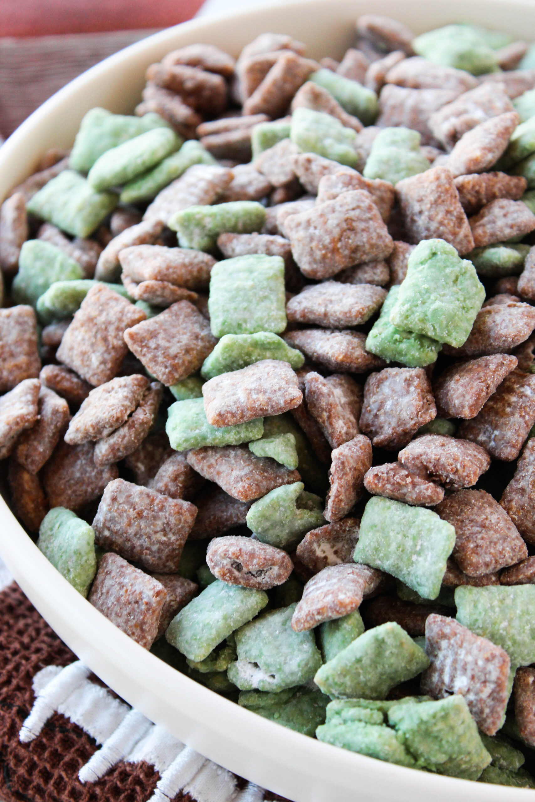 Bowl of football puppy chow topped with chocolate and peanut butter coating