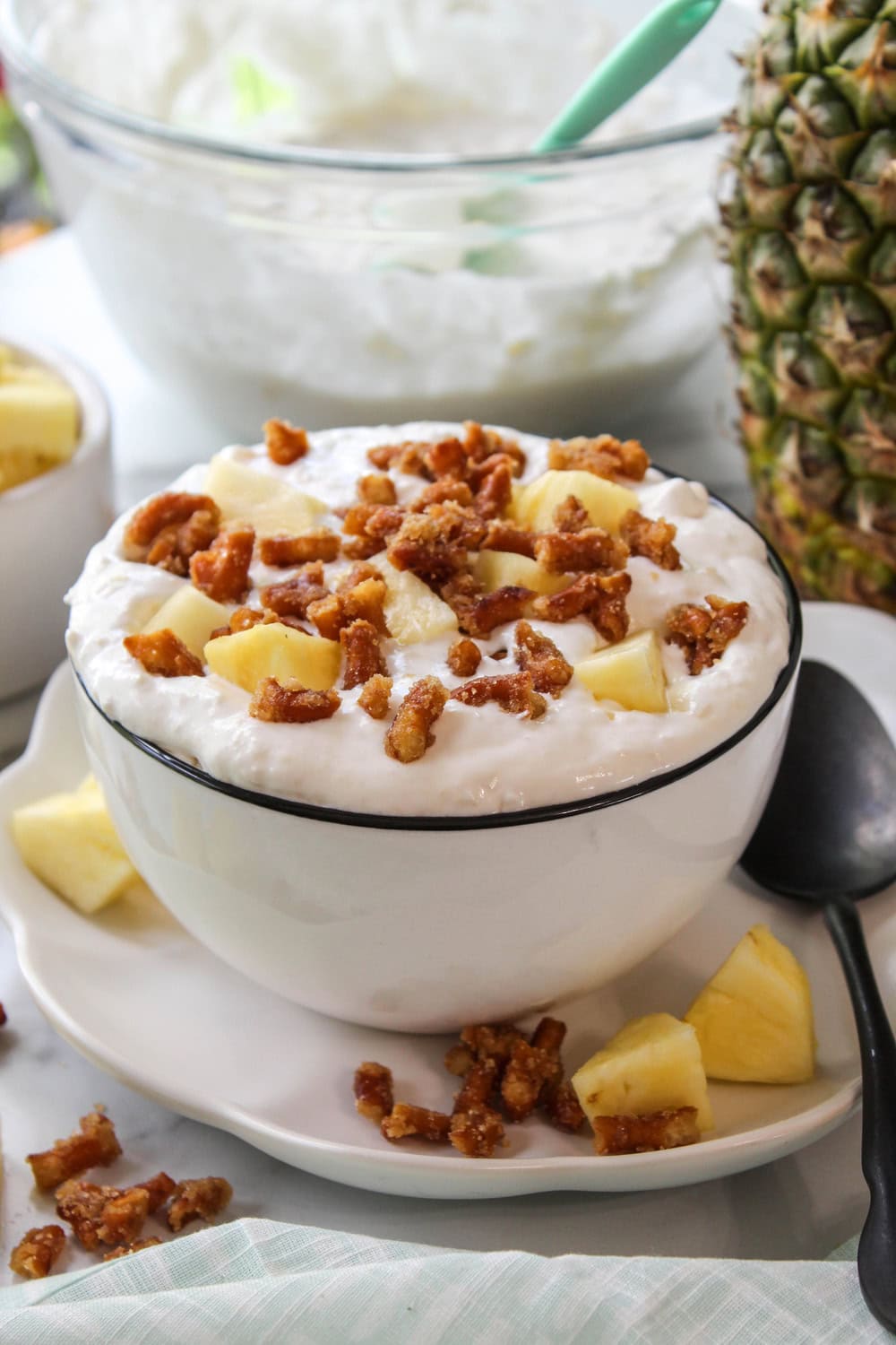 Close-up of pineapple pretzel fluff dessert, showing a creamy texture with bits of crushed pretzels and bright yellow pineapple