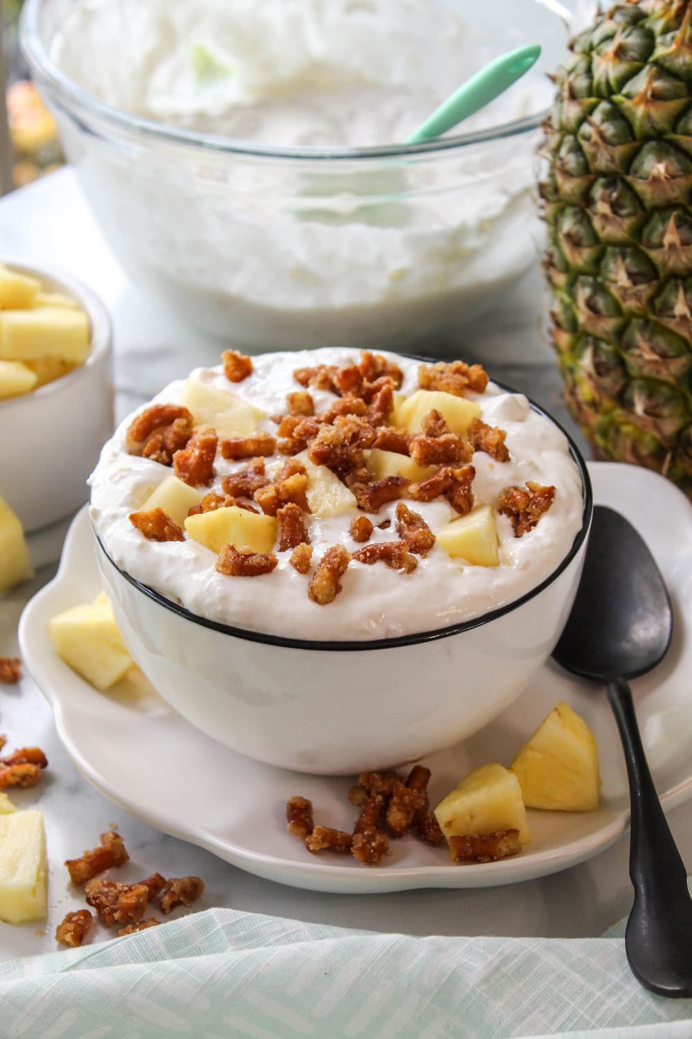Sweet and salty pineapple pretzel salad fluff topped with extra pretzel crumbles in a glass serving dish
