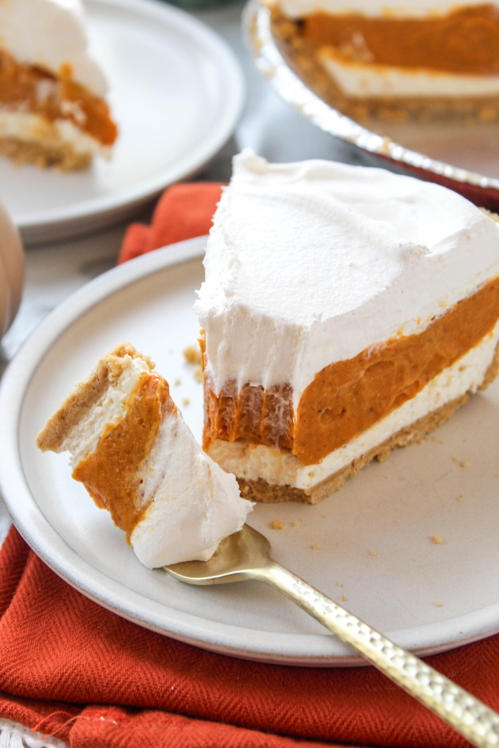 Triple layer pumpkin pie served on a dessert plate for fall entertaining