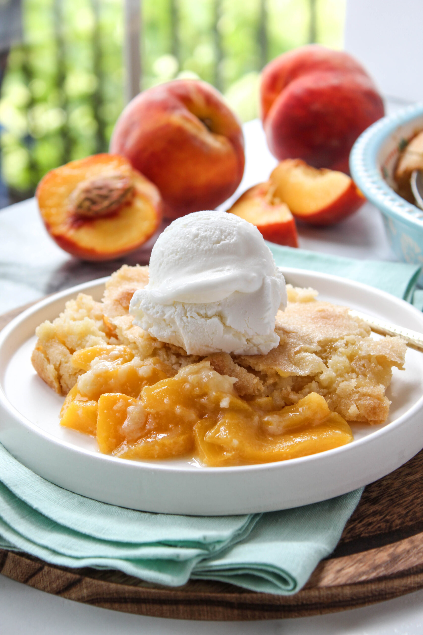 Peach cobbler served warm with a scoop of vanilla ice cream
