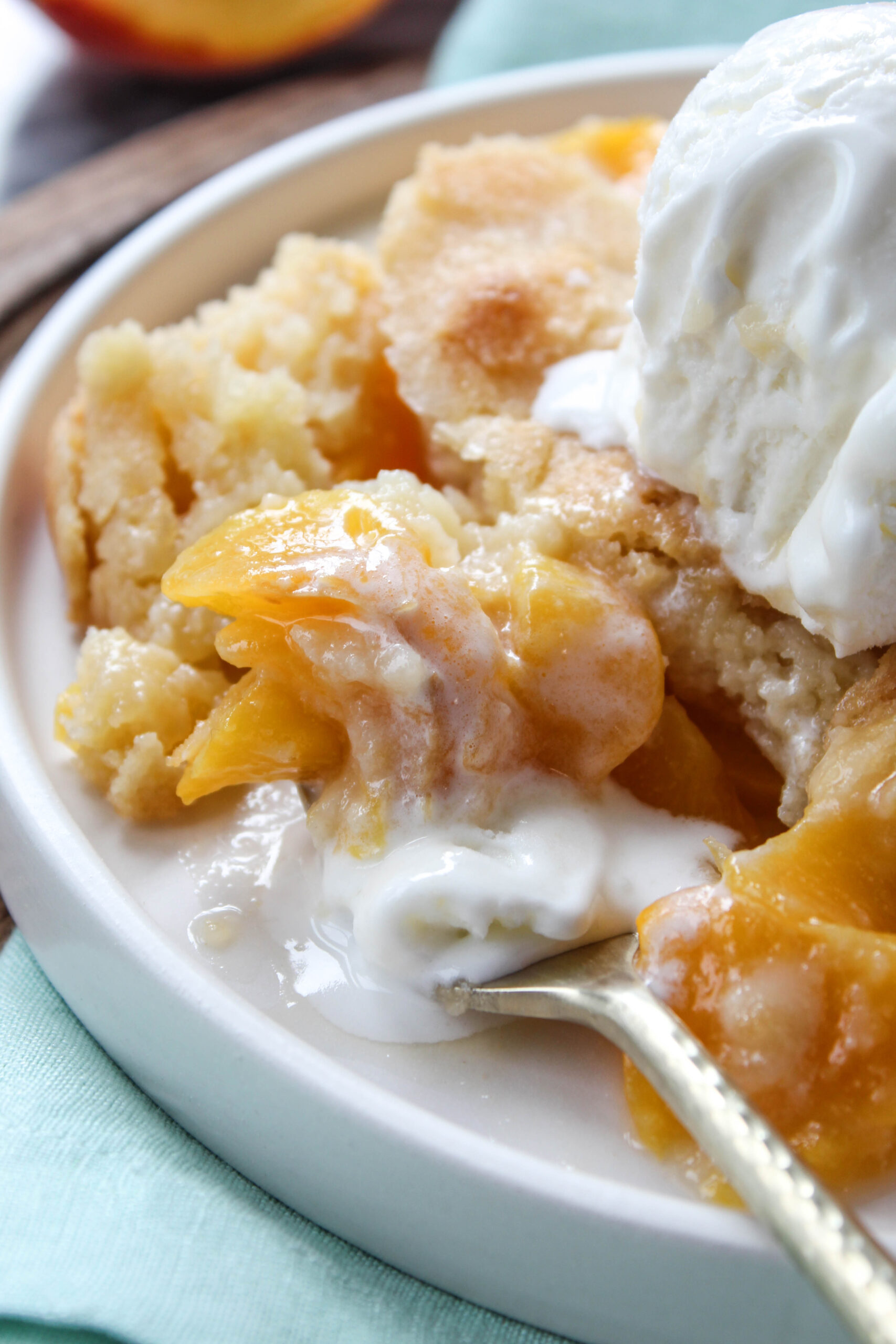 Close‑up of peach cobbler showing soft peaches and golden crust