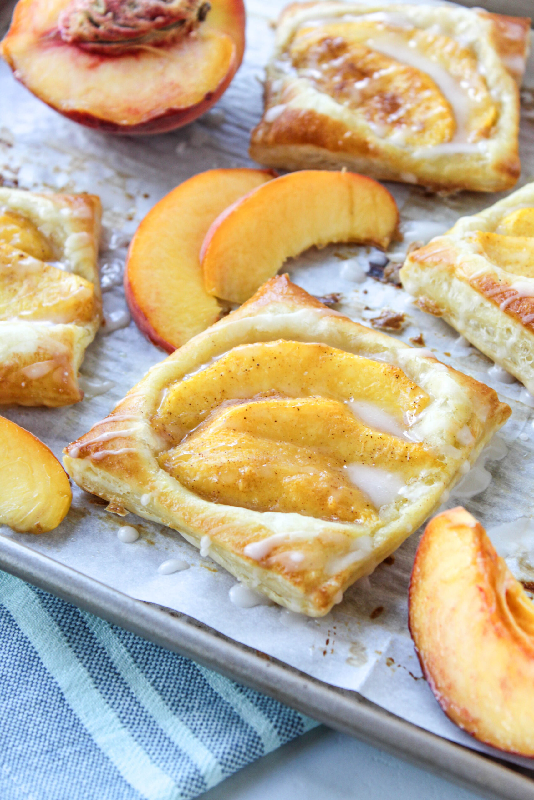 Peach puff pastry tarts on a baking sheet