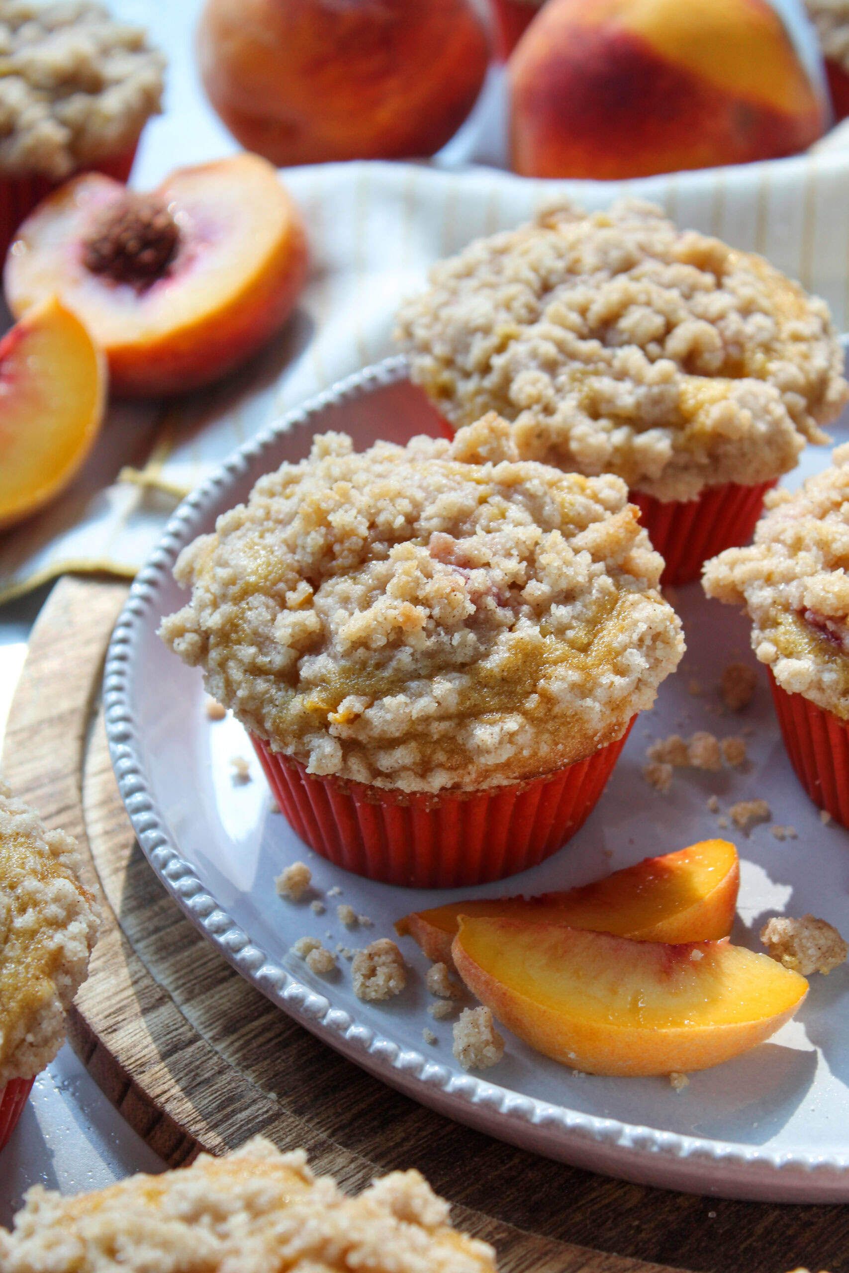 Warm peach cobbler muffins bursting with ripe peaches and topped with a cinnamon crumb streusel