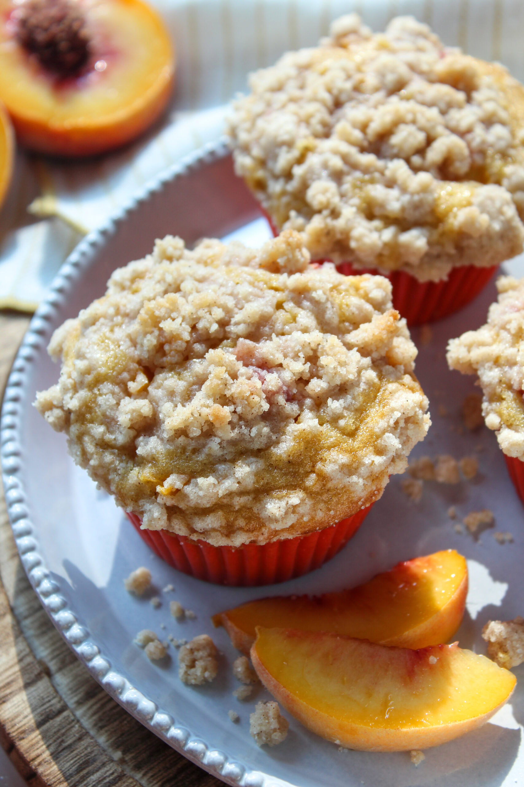 Freshly baked peach muffins with golden tops and sweet cobbler-style crumble