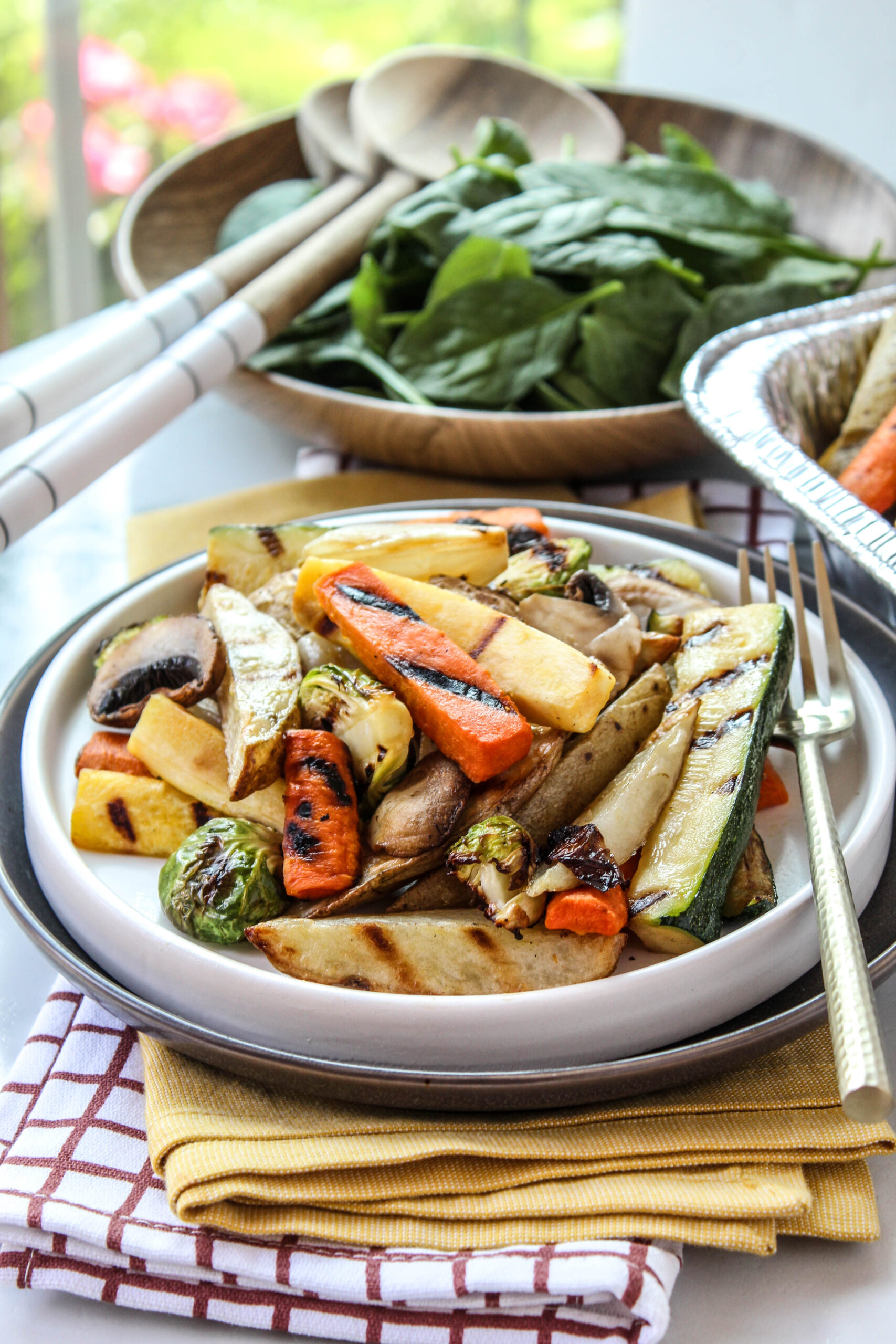 Mixed air fryer vegetables arranged on a plate with bright, roasted color