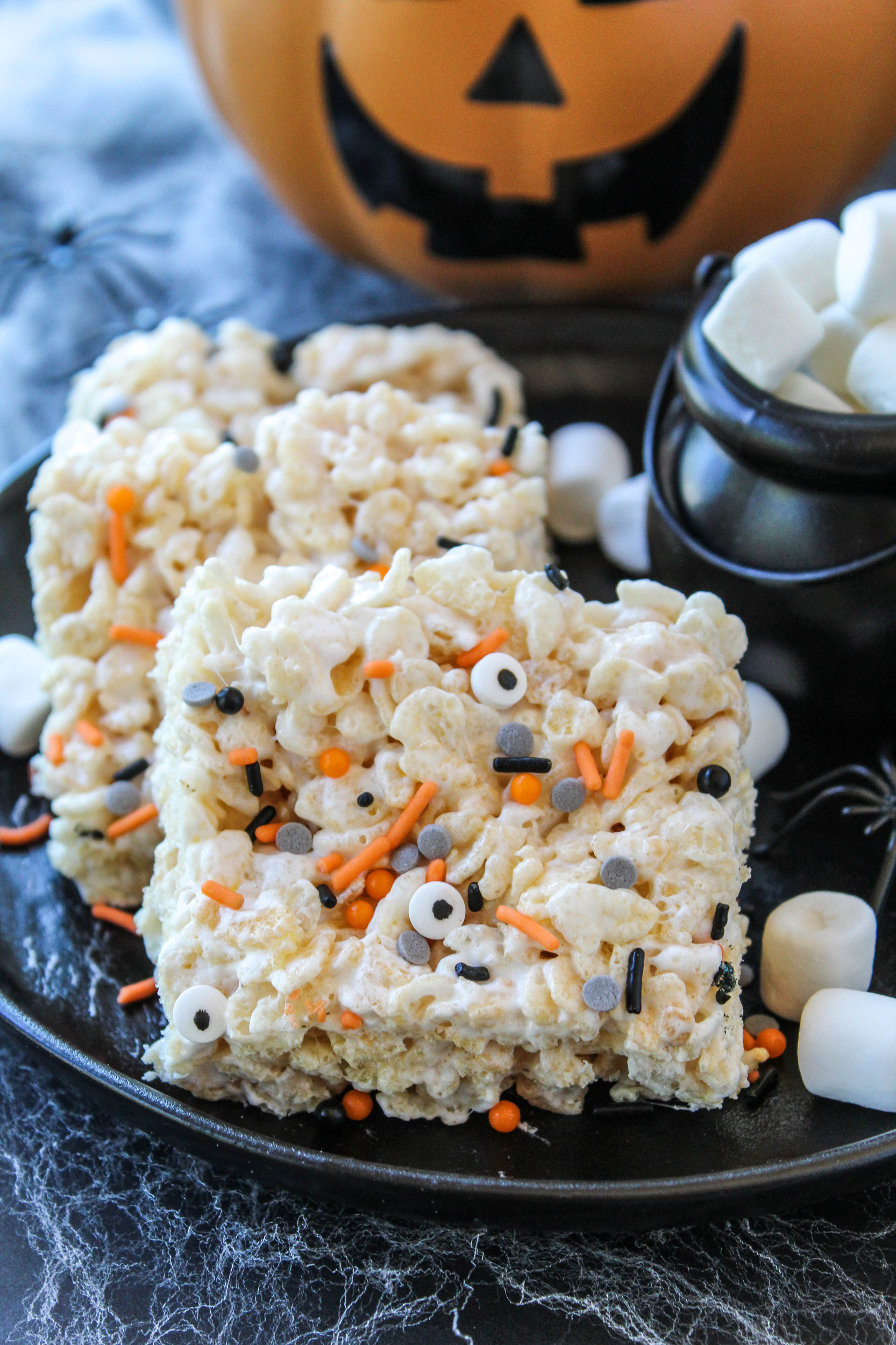 Rice Krispie marshmallow treats cut into squares and decorated for Halloween