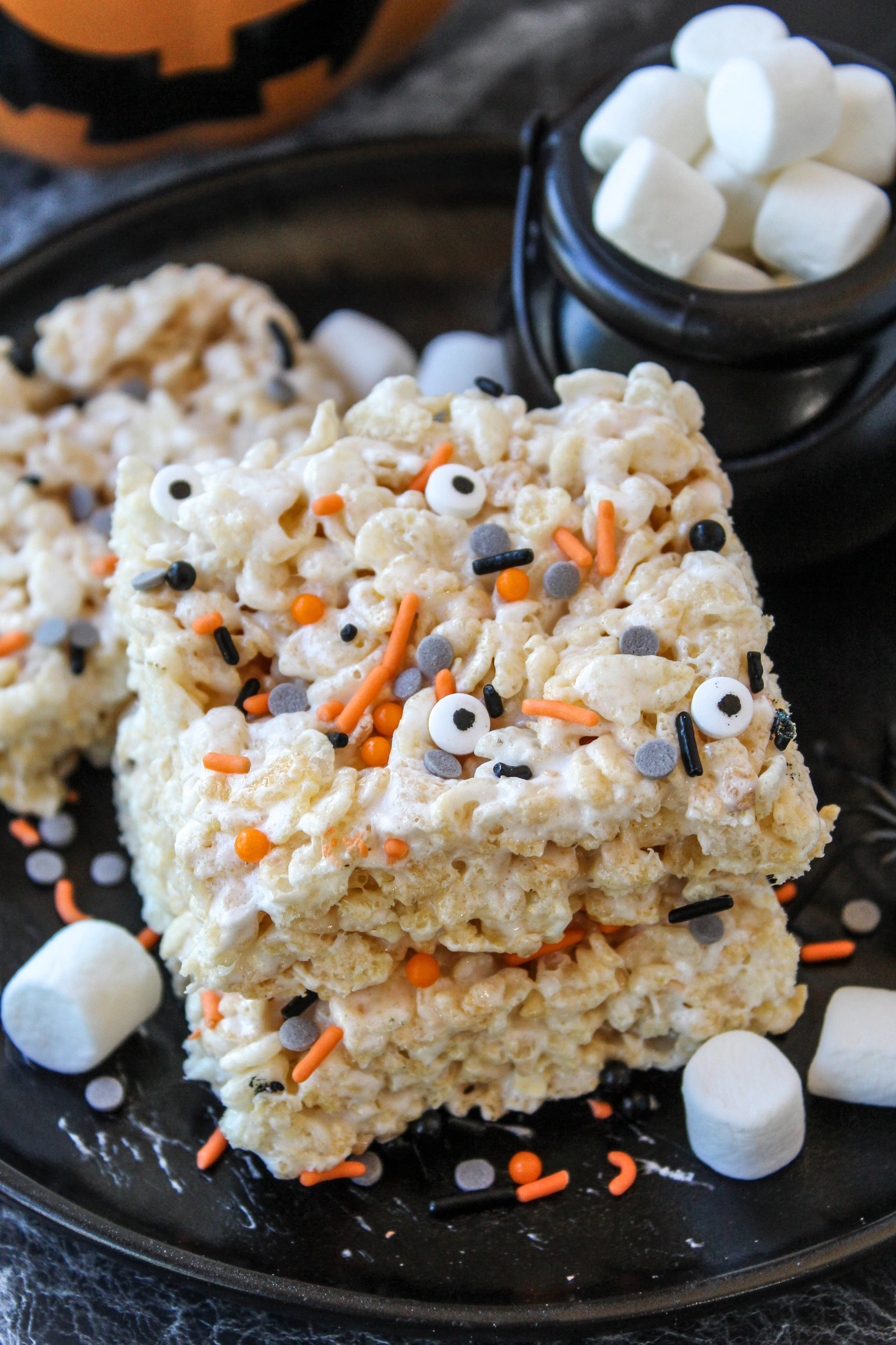 Halloween Rice Krispie treats arranged on a black serving tray