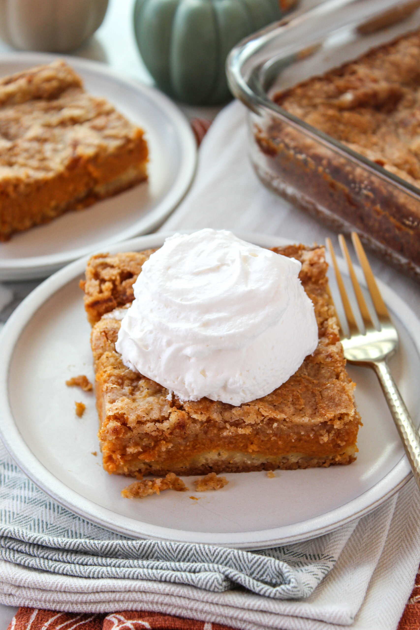 Slice of pumpkin pie cake showing soft pumpkin layer and cake mix topping