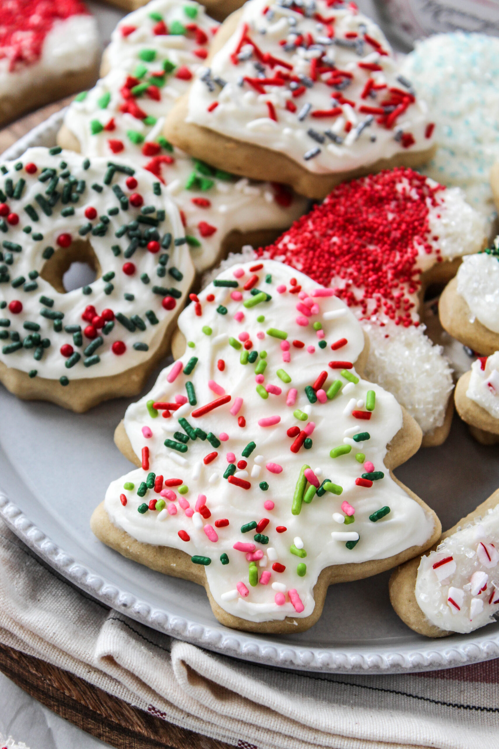 Soft sugar cookies decorated with cream cheese icing and Christmas sprinkles