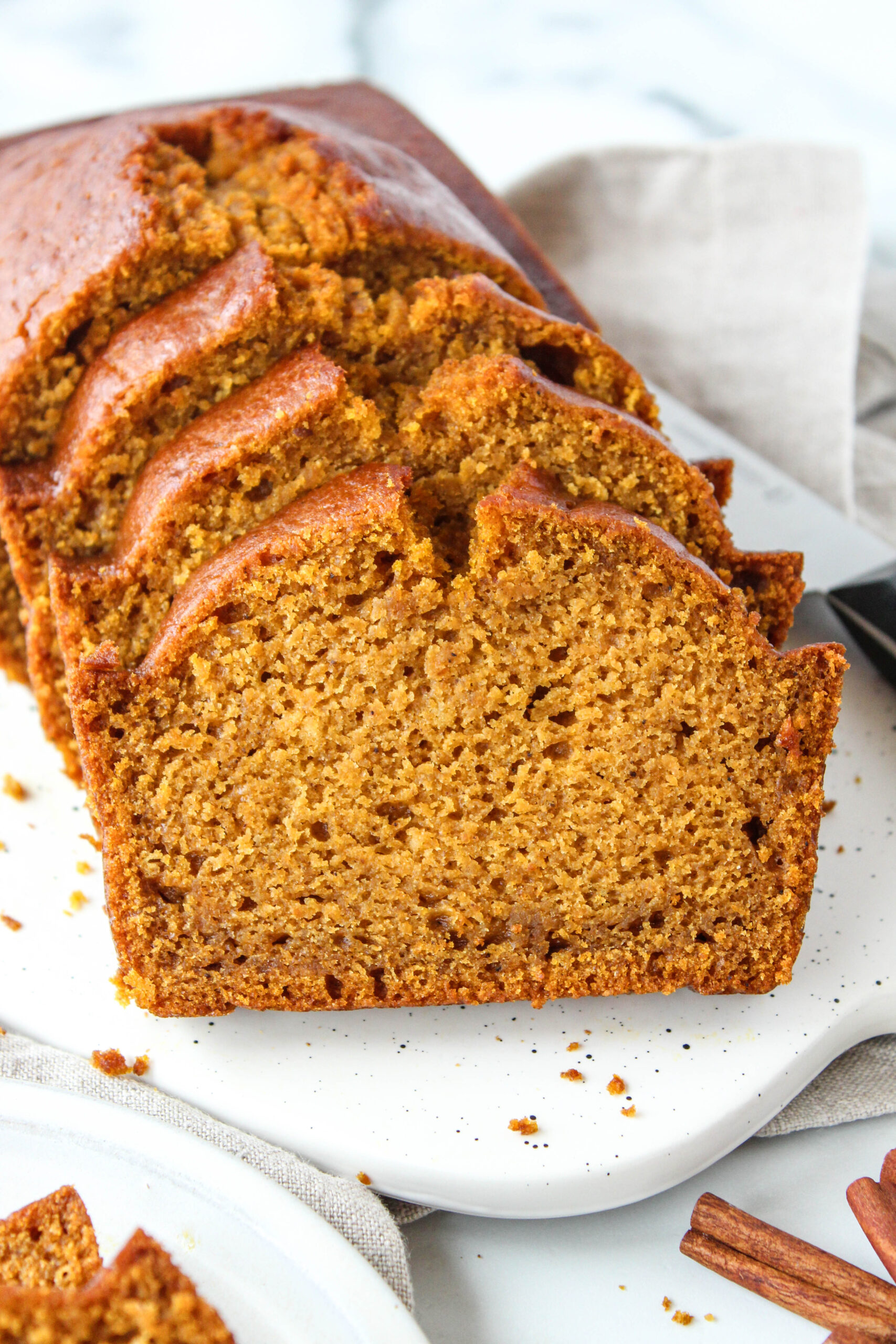 Pumpkin bread loaf with a golden top and soft, cozy interior.