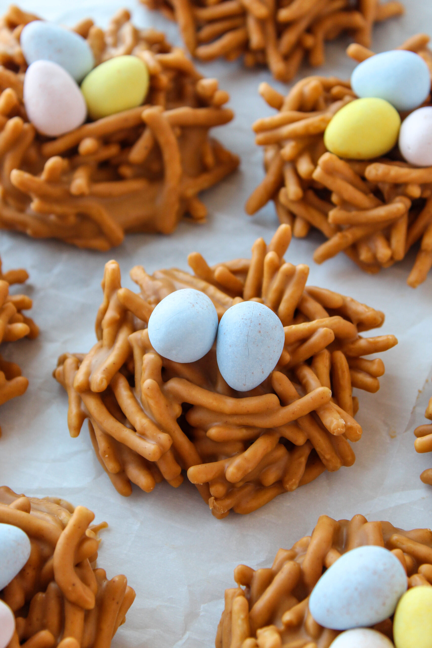 No‑bake butterscotch and peanut butter bird nest cookies made with crunchy noodles and chocolate Easter eggs.