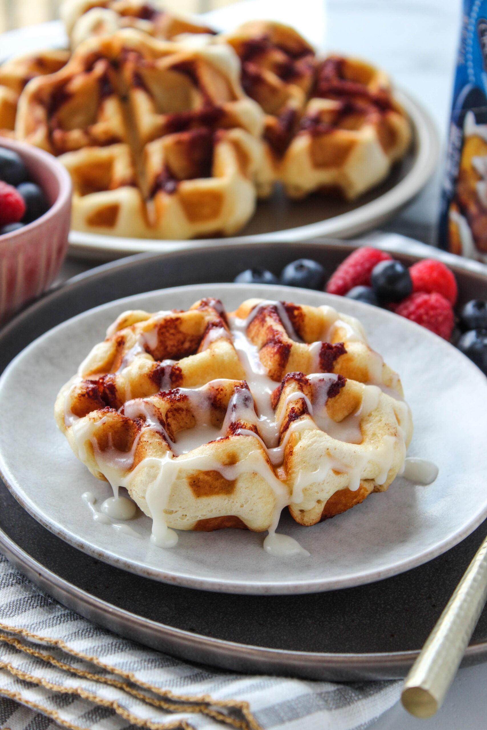 Easy breakfast waffles made from cinnamon rolls and topped with icing