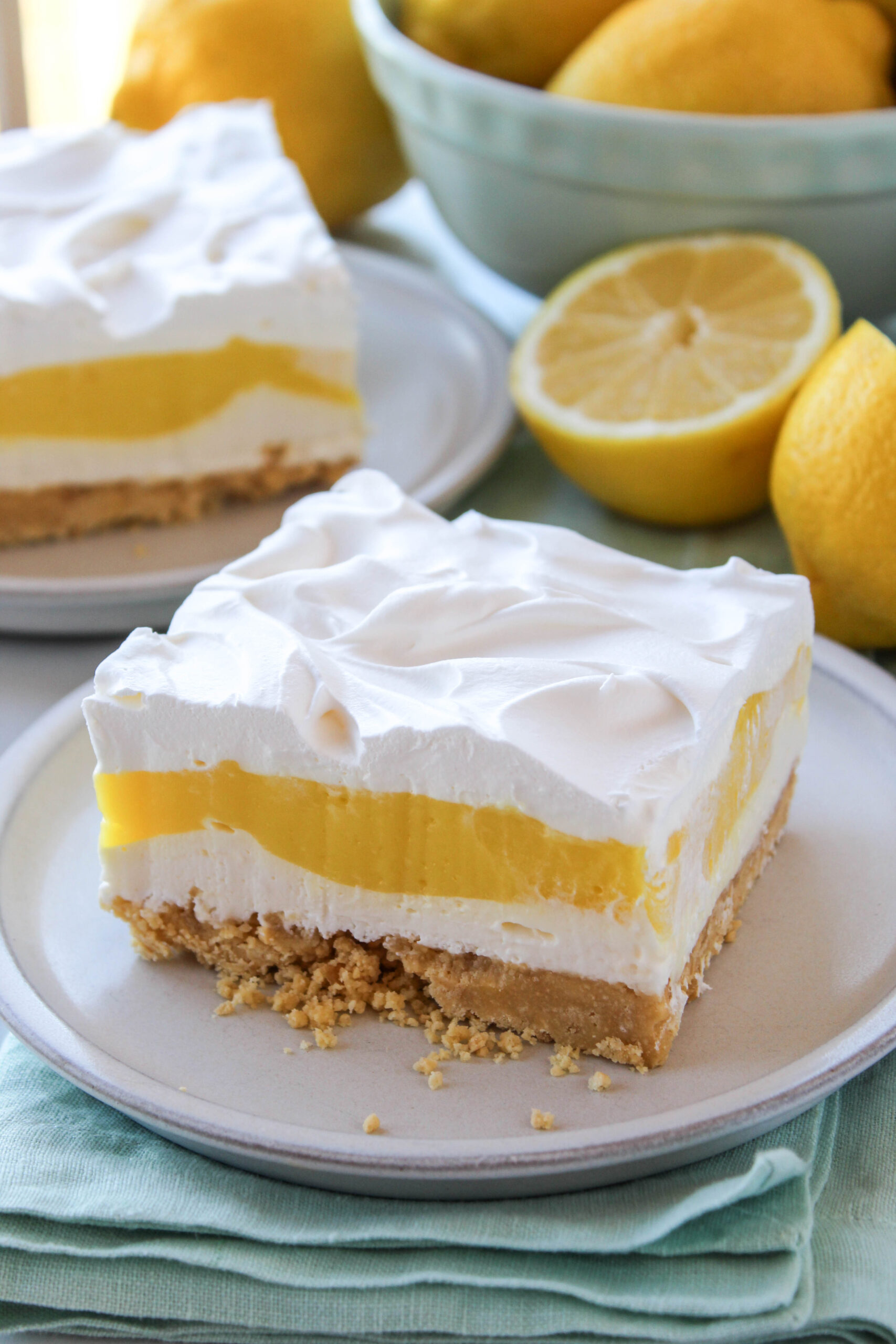 Close-up of lemon lasagna slice with creamy yellow pudding layers and fluffy whipped topping