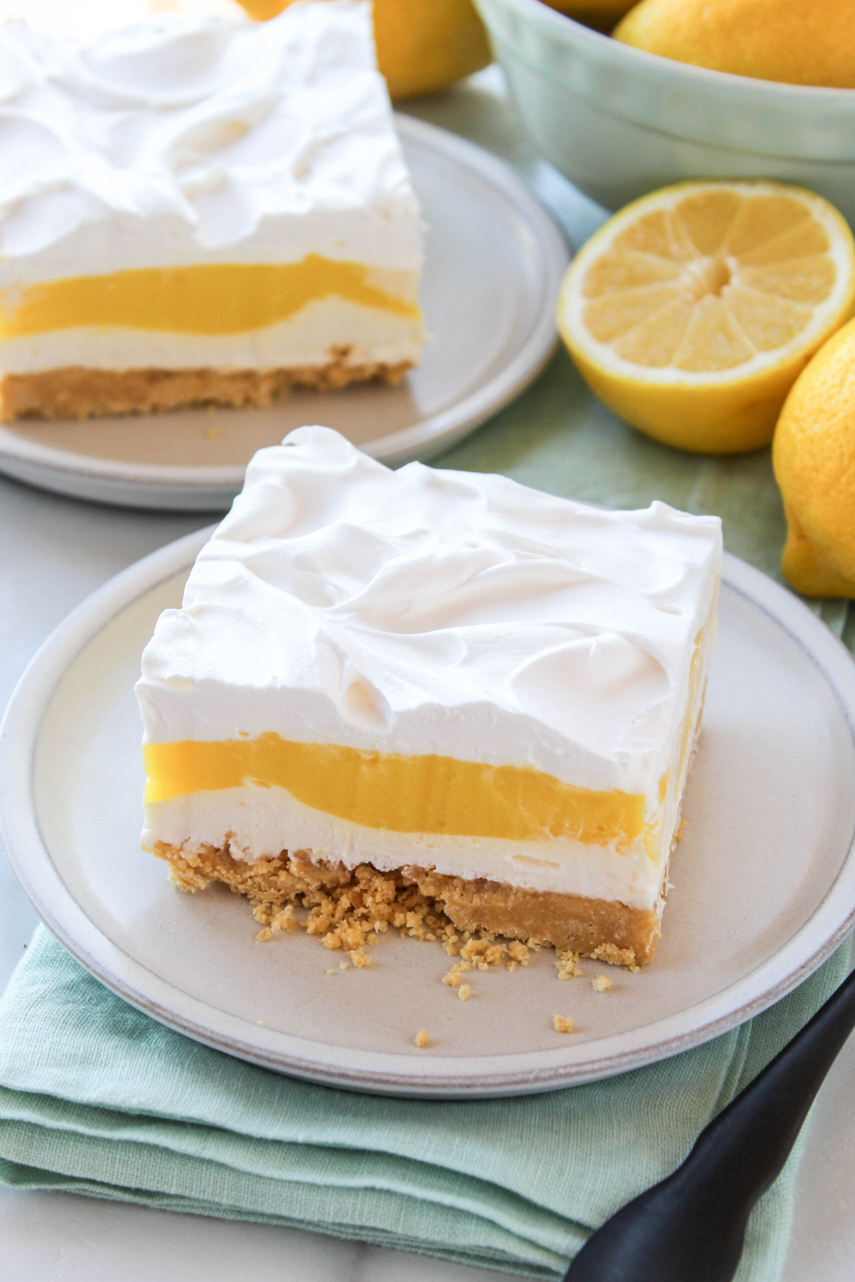 Slice of no-bake lemon lasagna showing creamy lemon layers and cookie crust