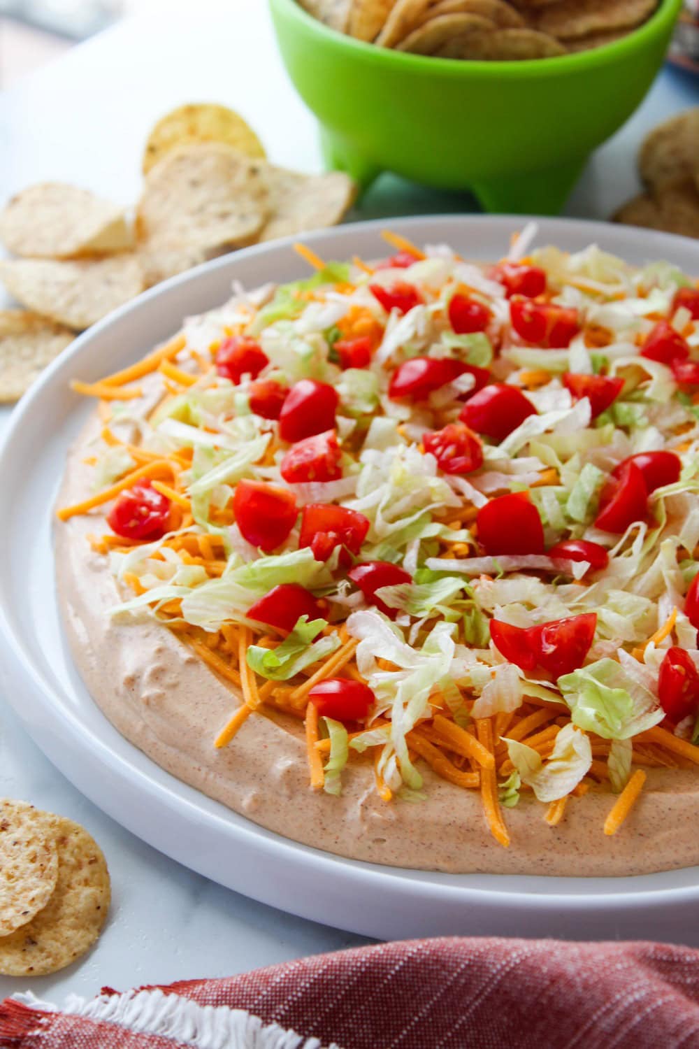 Easy taco dip served in a glass dish with colorful layers and fresh toppings