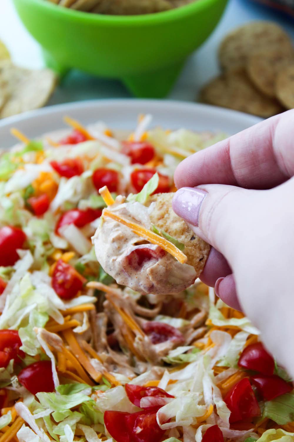 Crowd-pleasing taco dip recipe served with tortilla chips for a party appetizer