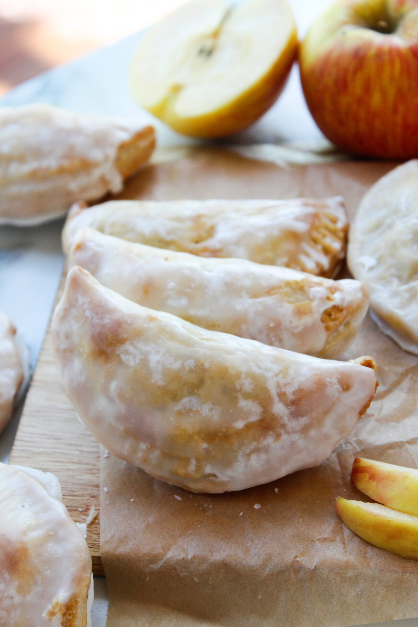 Freshly baked apple hand pies arranged on a wooden board