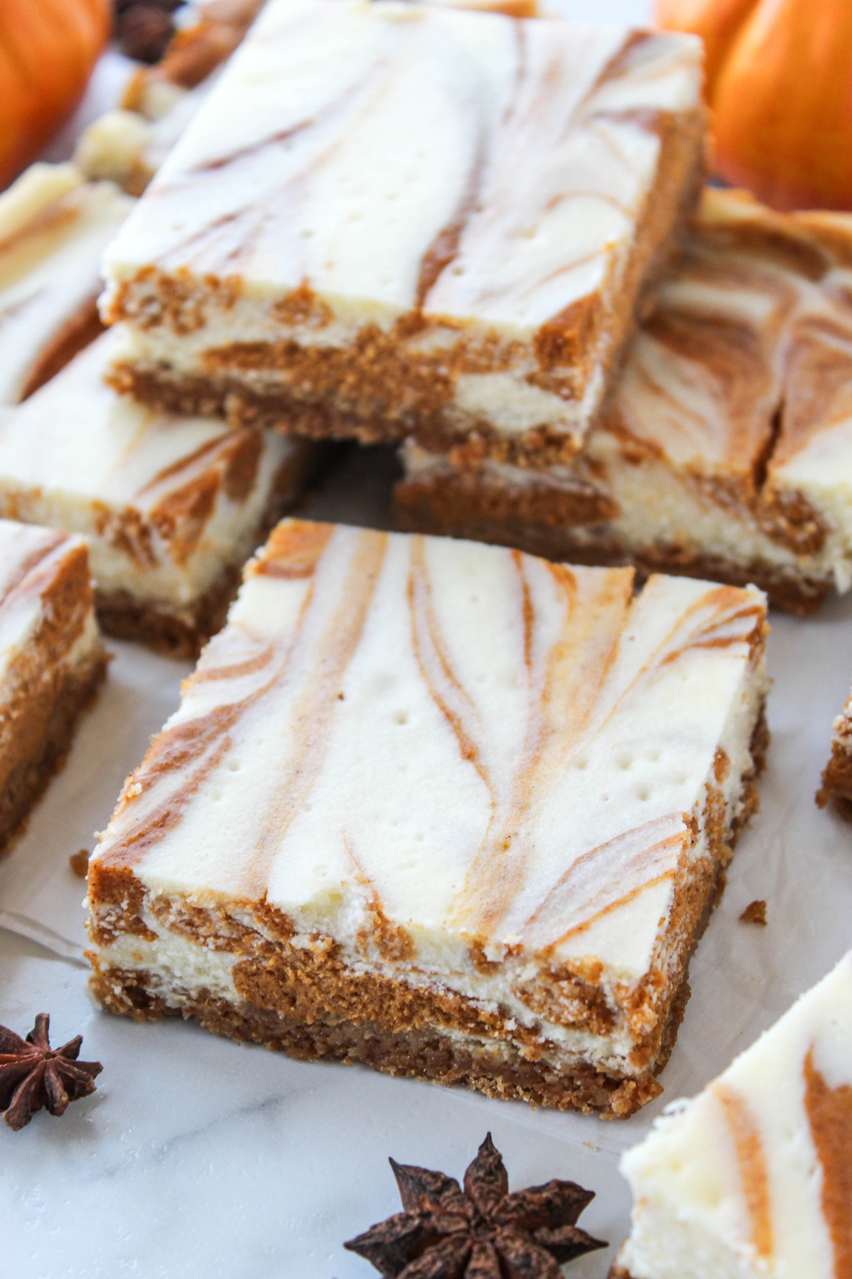 Close‑up of pumpkin cheesecake bars showing the orange pumpkin swirl pattern