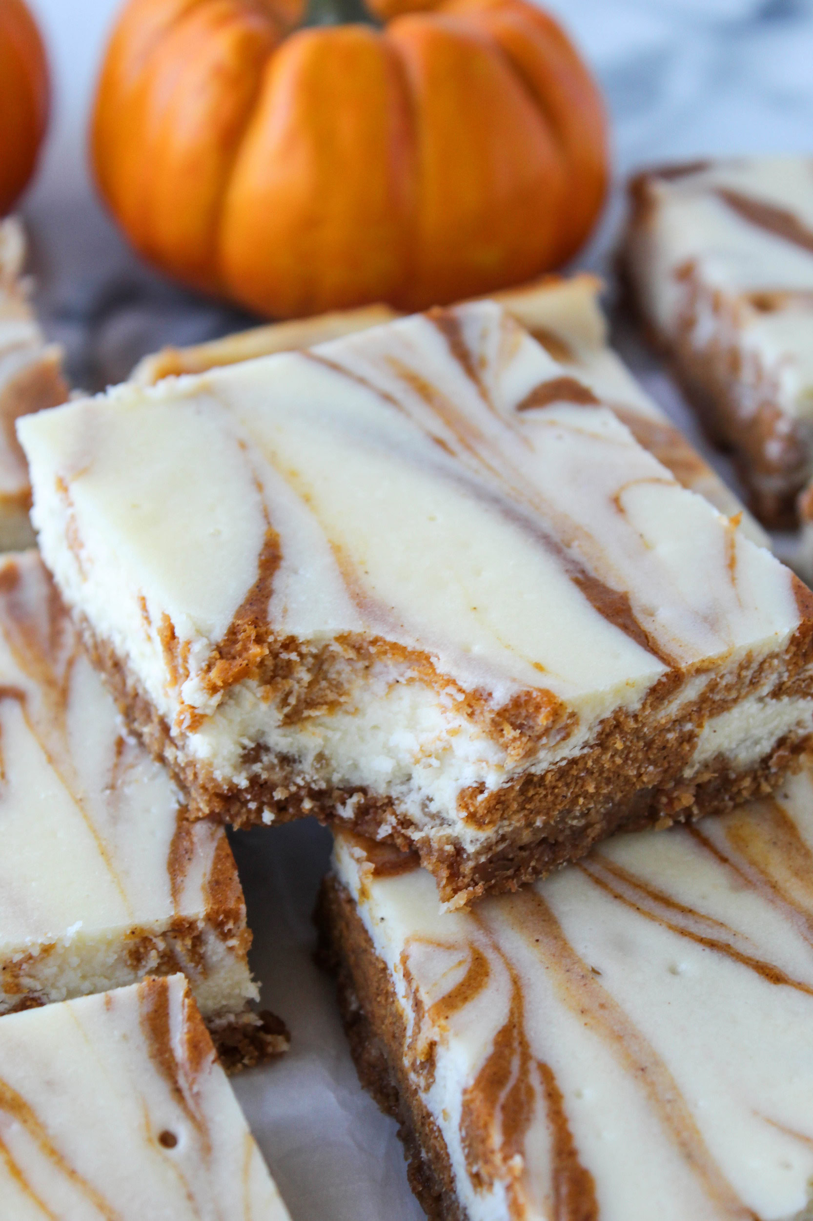 Stacked pumpkin cheesecake bars showing the thick creamy layers and golden crust
