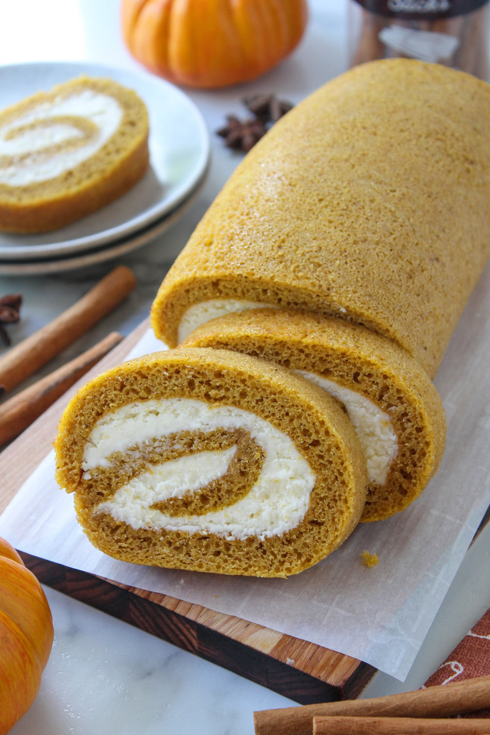 Sliced pumpkin roll showing the swirl of rich cream cheese filling