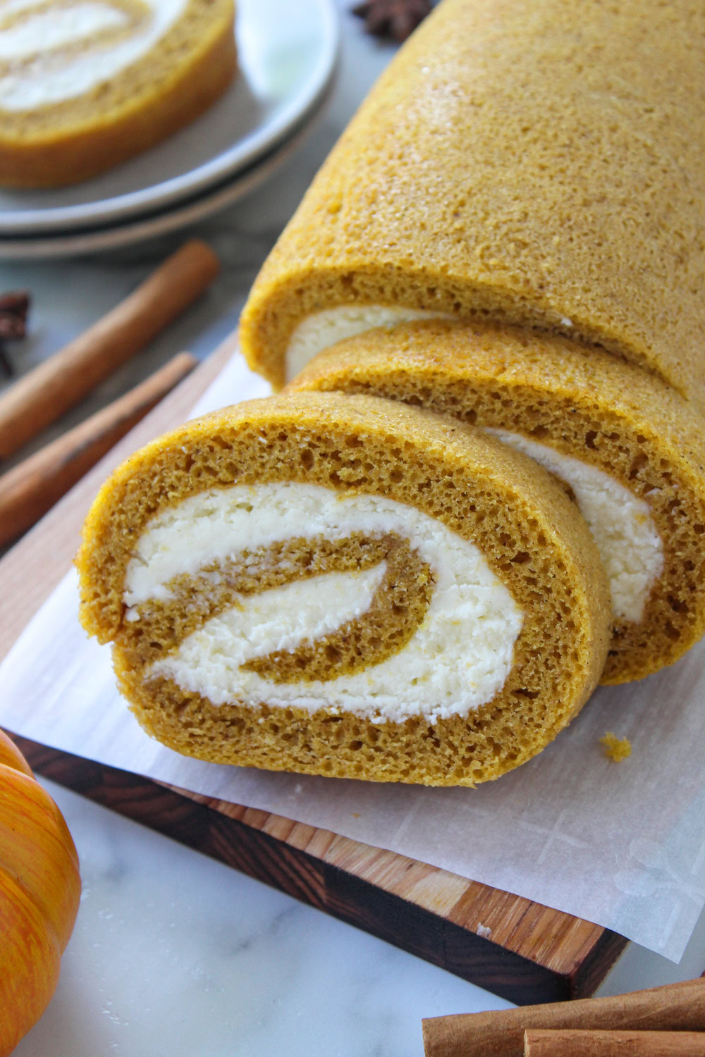 Close‑up of pumpkin roll with a thick cream cheese swirl