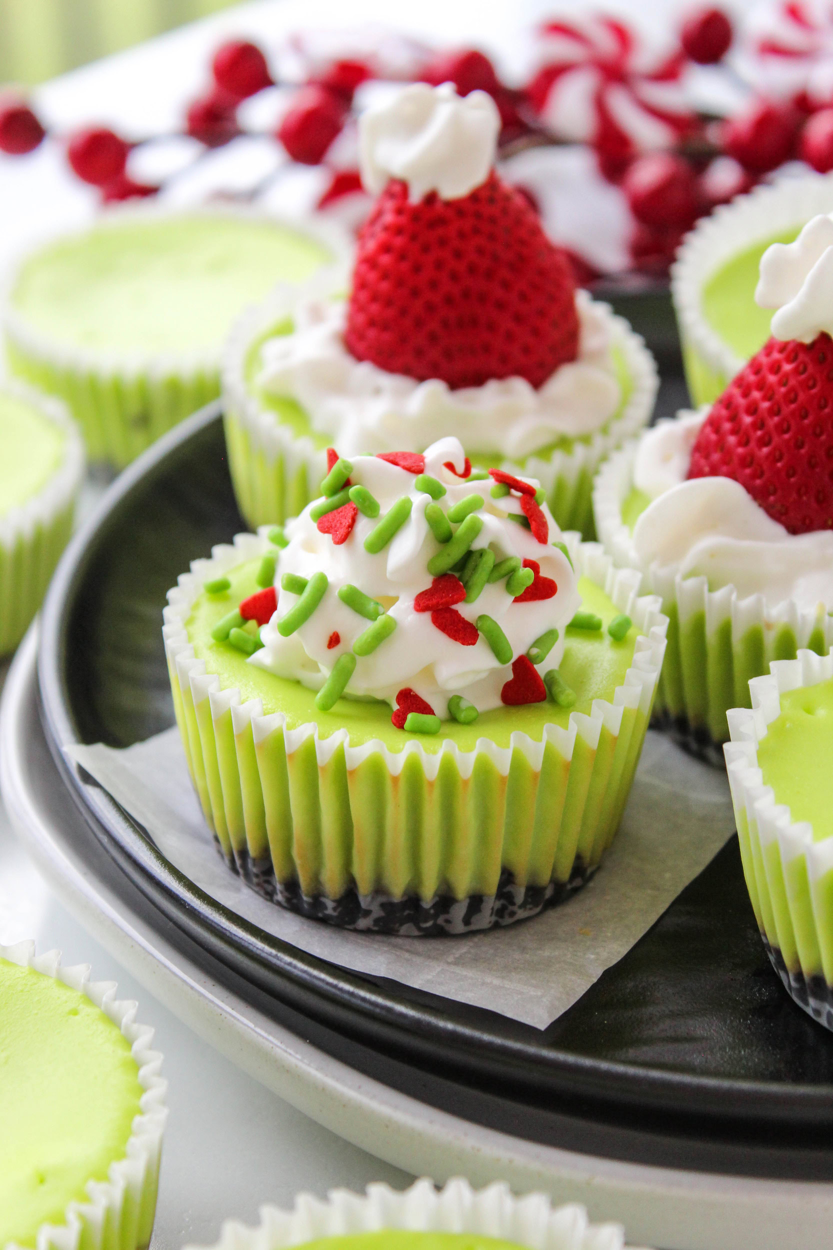 Festive green mini cheesecakes inspired by the Grinch with red heart decoration