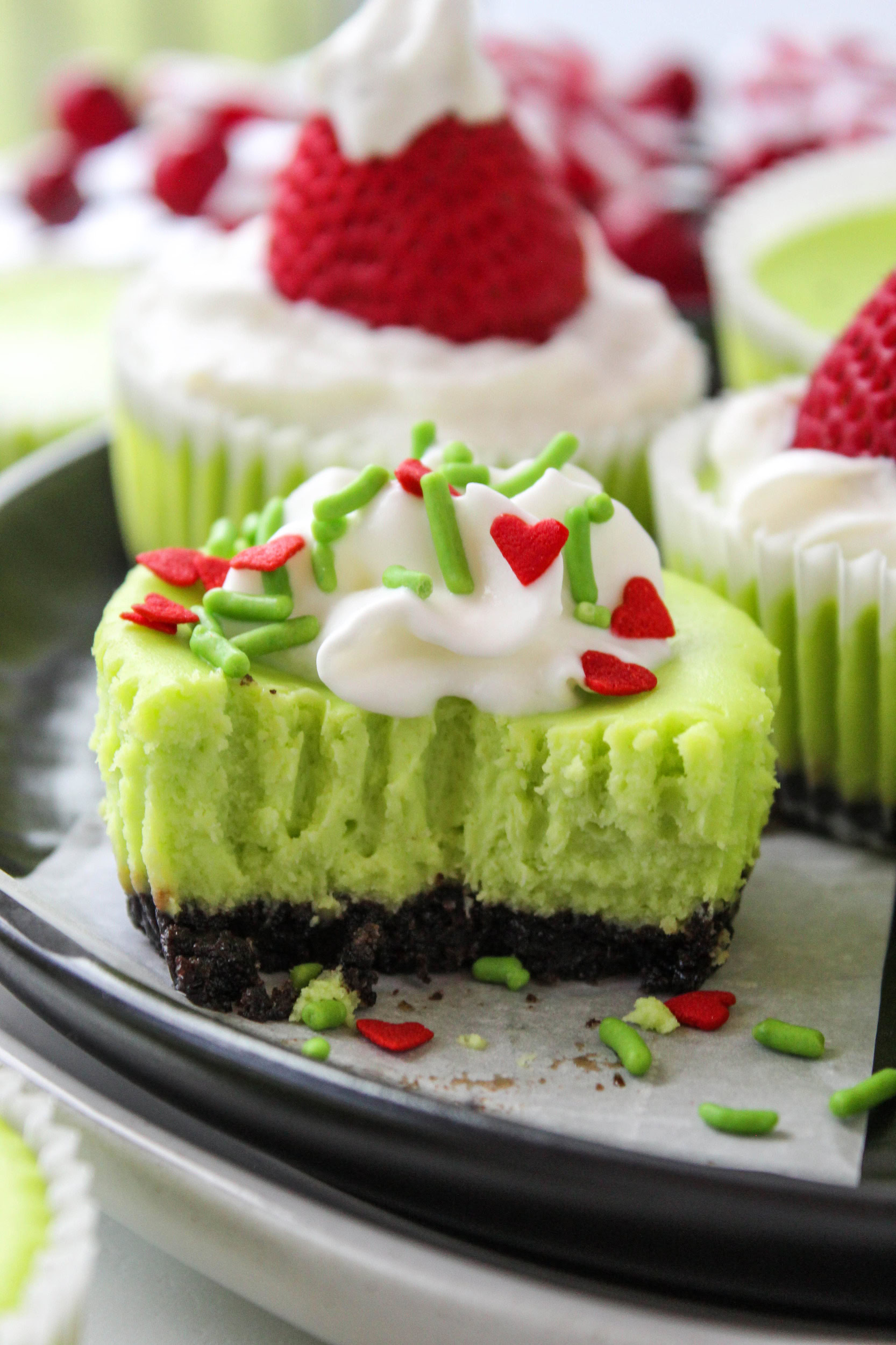 Homemade mini cheesecakes colored Grinch green with heart sprinkles