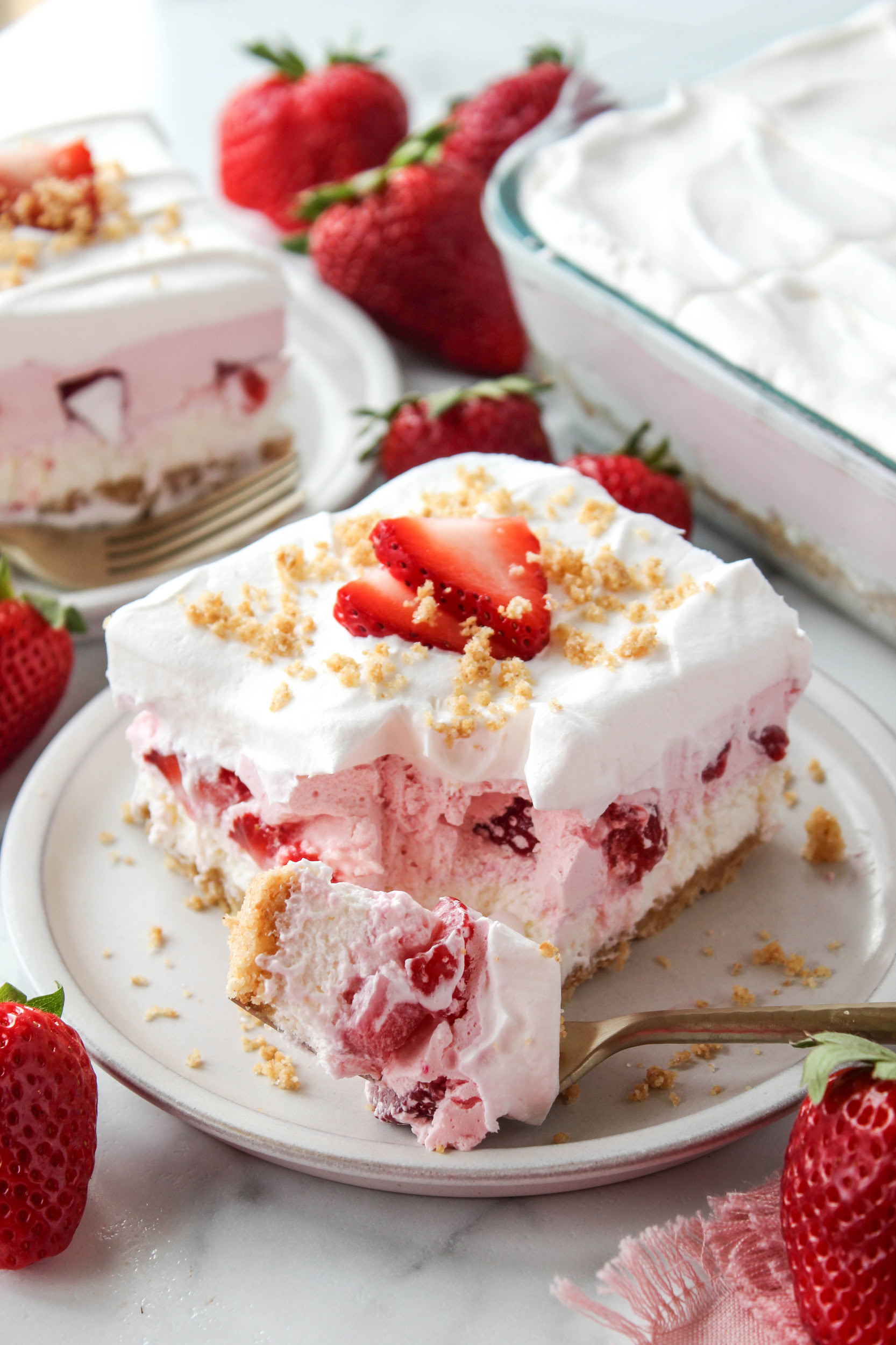 Homemade strawberry lasagna with a buttery crust, cheesecake layer, and bright red fresh strawberries