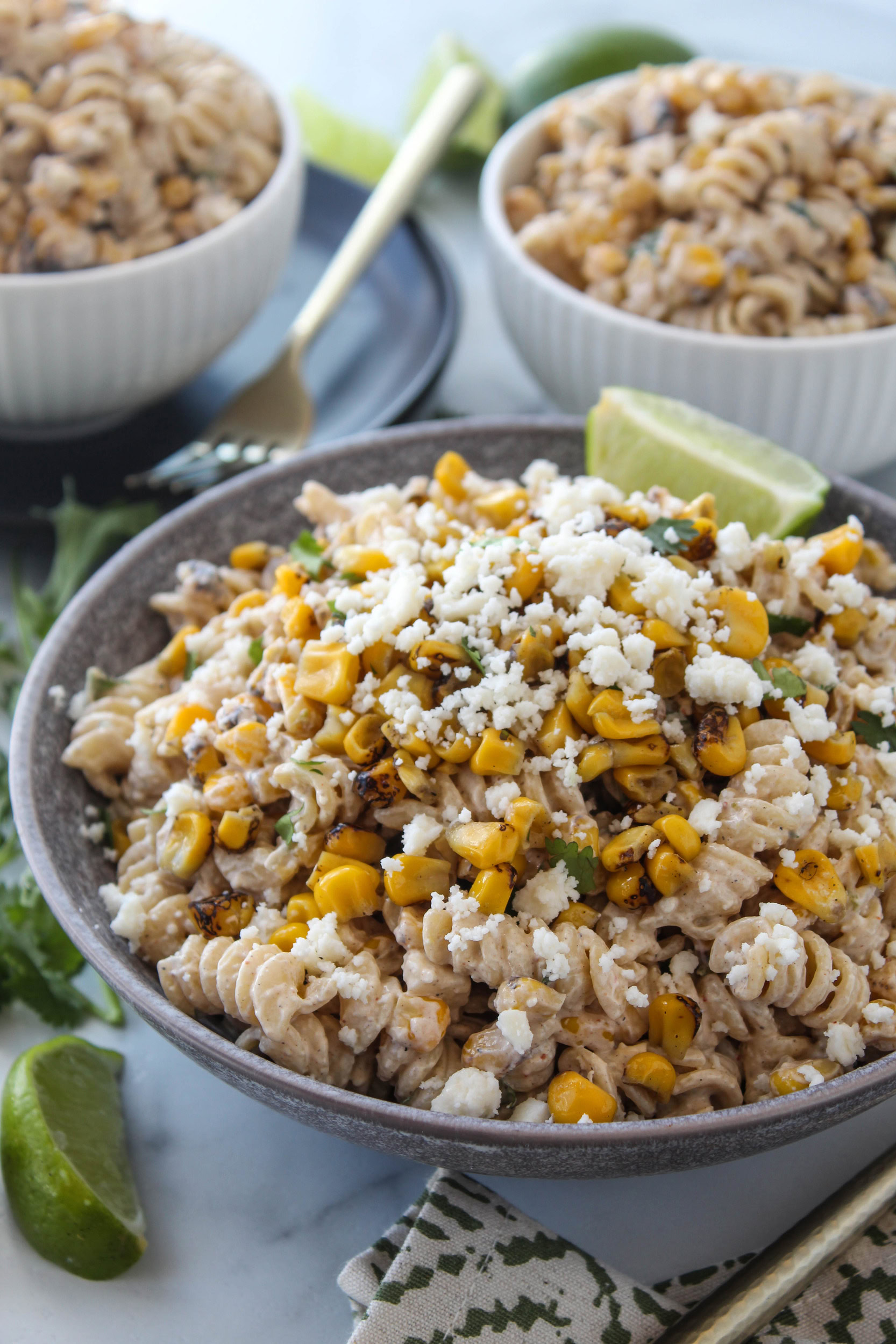 Close-up of Mexican street corn pasta salad featuring rotini pasta, roasted corn, fresh herbs, and crumbled cheese