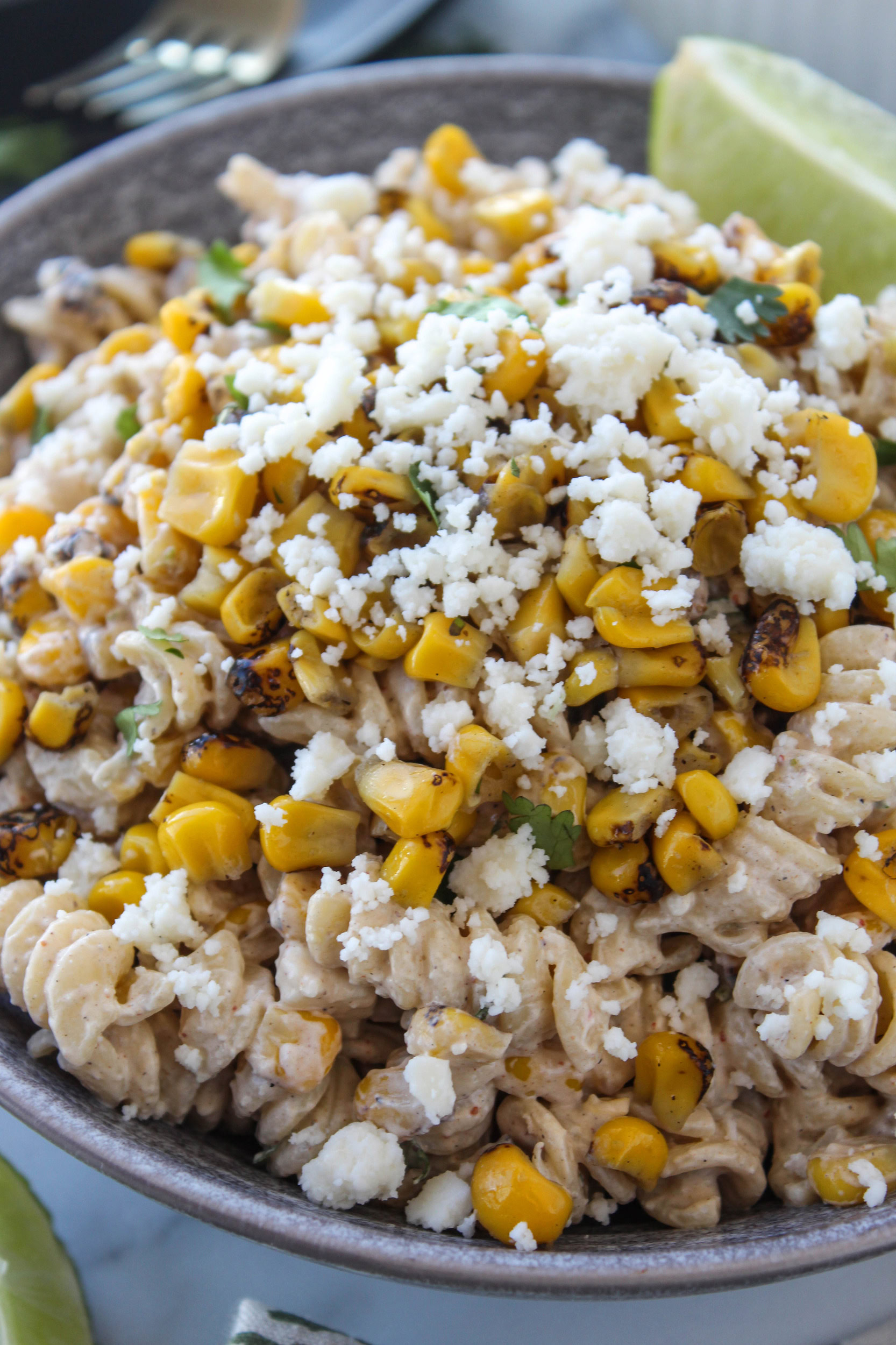 Mexican street corn pasta salad with spiral pasta, charred corn, cilantro, cheese, and a creamy chili-lime dressing