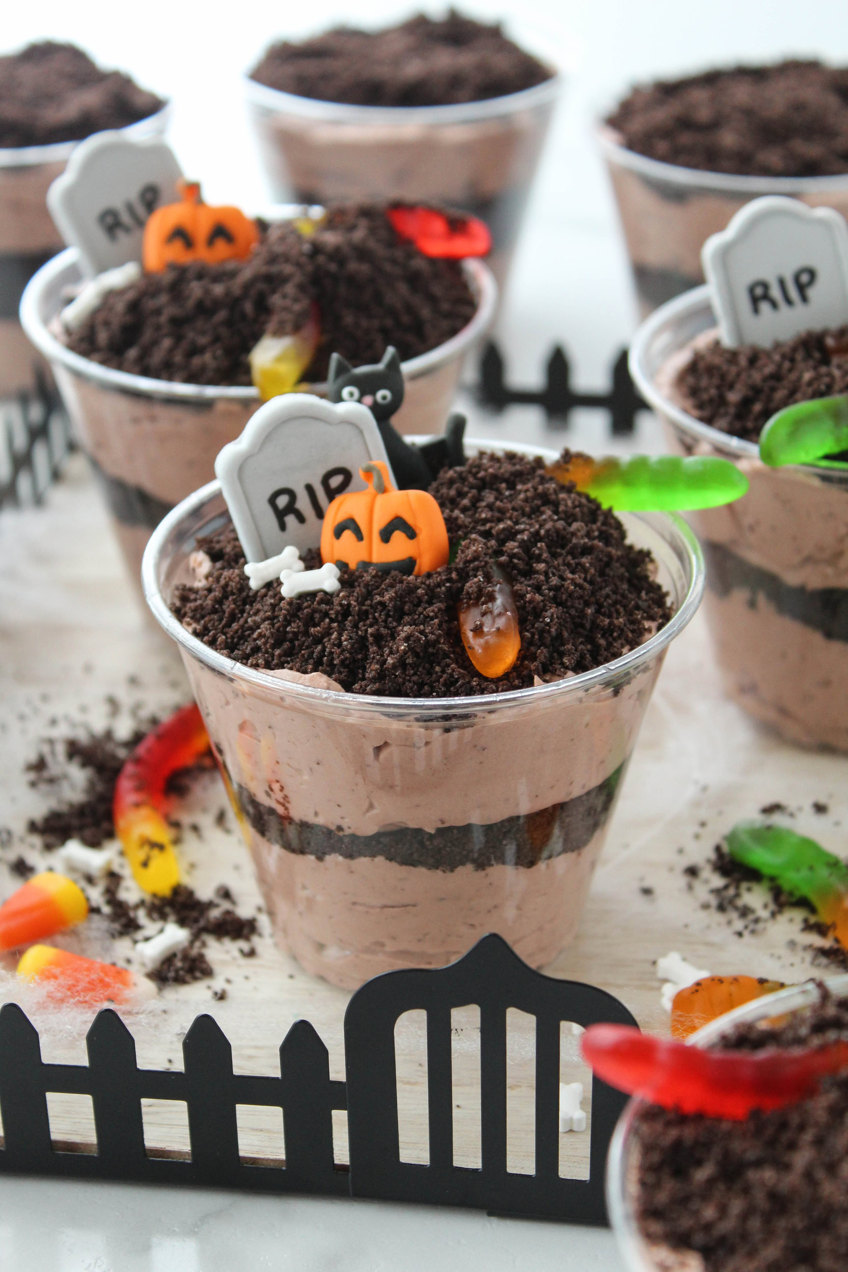 Halloween Oreo dirt cake cups topped with gummy worms and crushed Oreo cookies