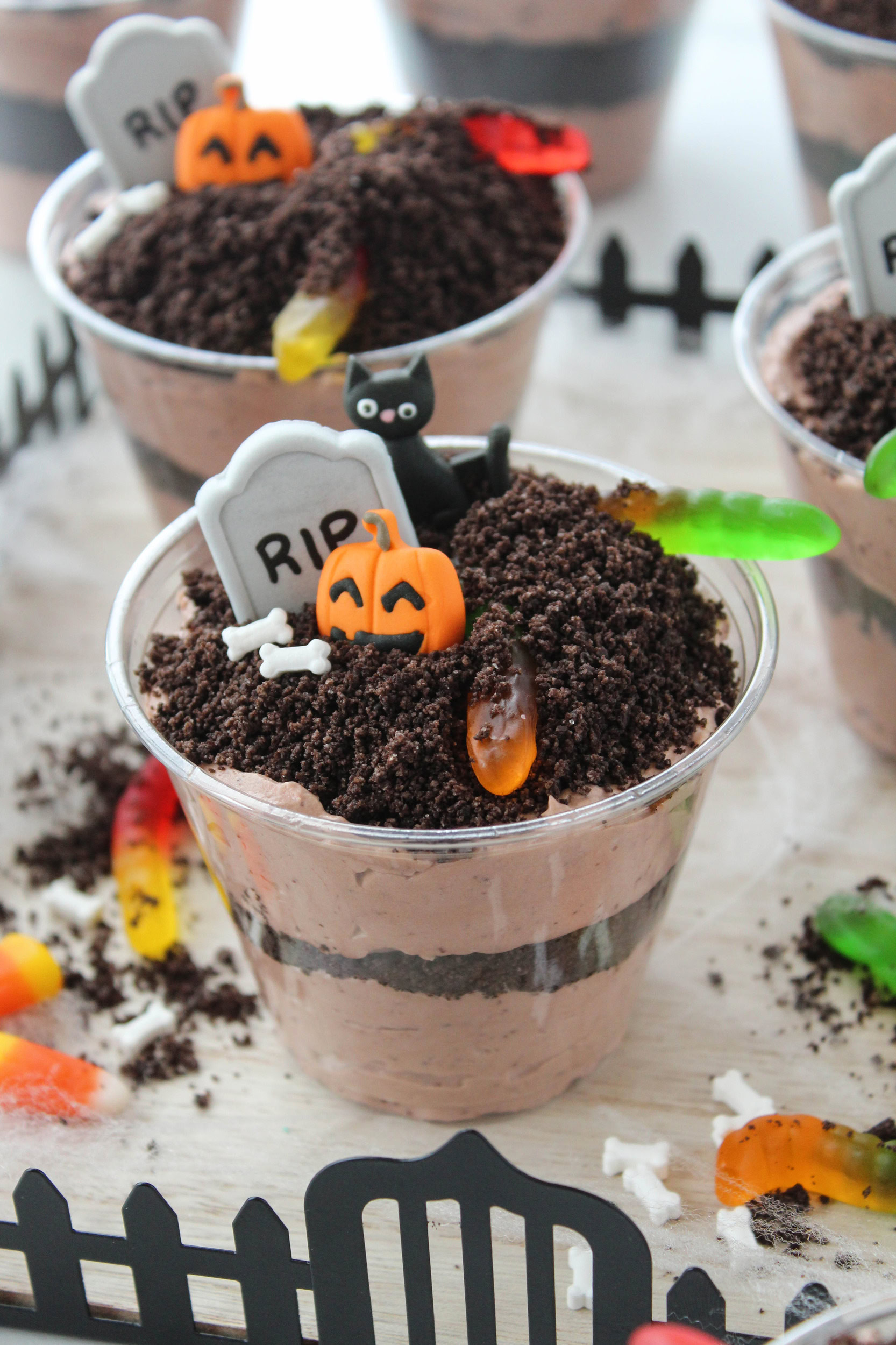 Individual Halloween dirt cake cups made with chocolate pudding and Oreo crumbs