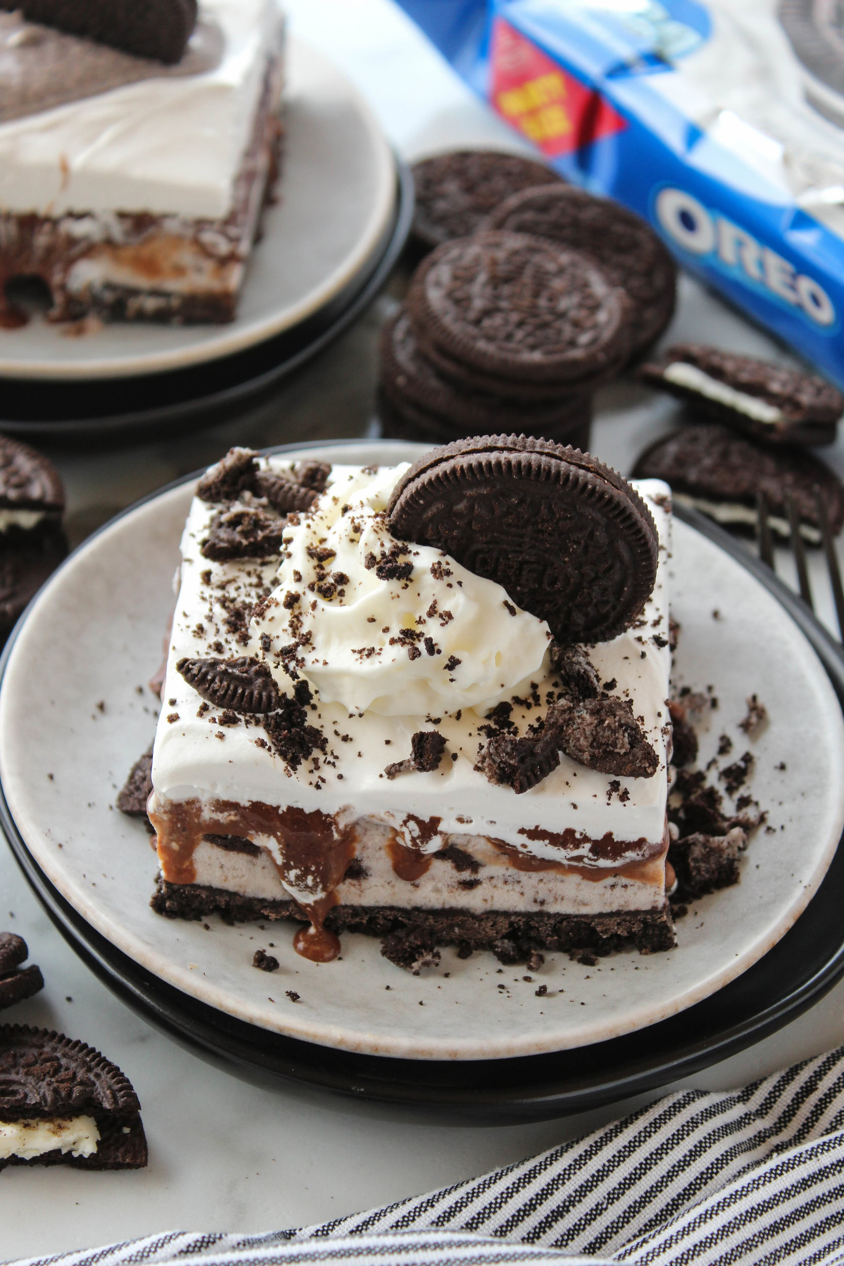 Homemade Oreo ice cream cake topped with fluffy whipped cream and crushed Oreo cookies